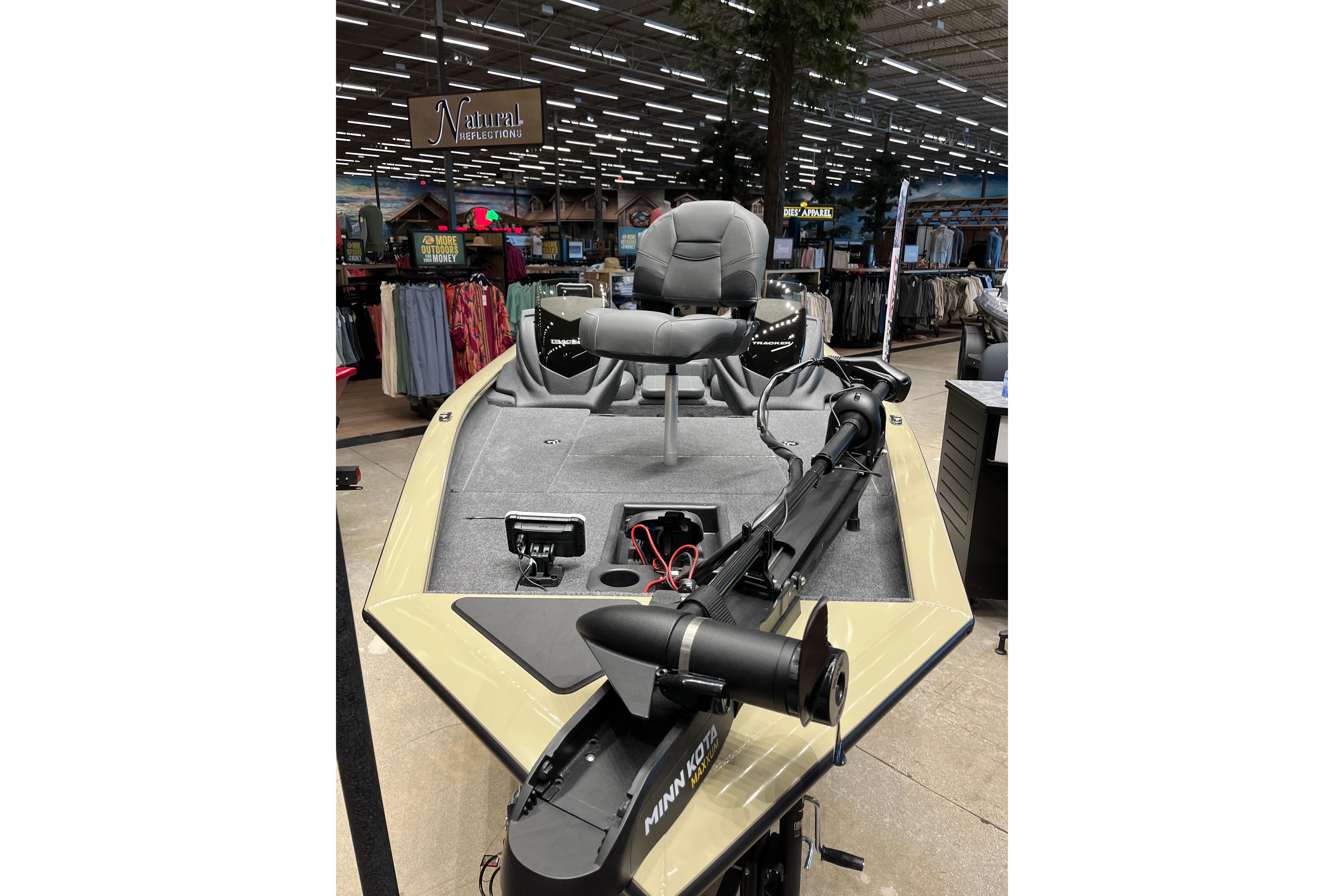 2026 Tracker Pro Team 175 boat displayed in a store, featuring a comfortable seat and trolling motor.
