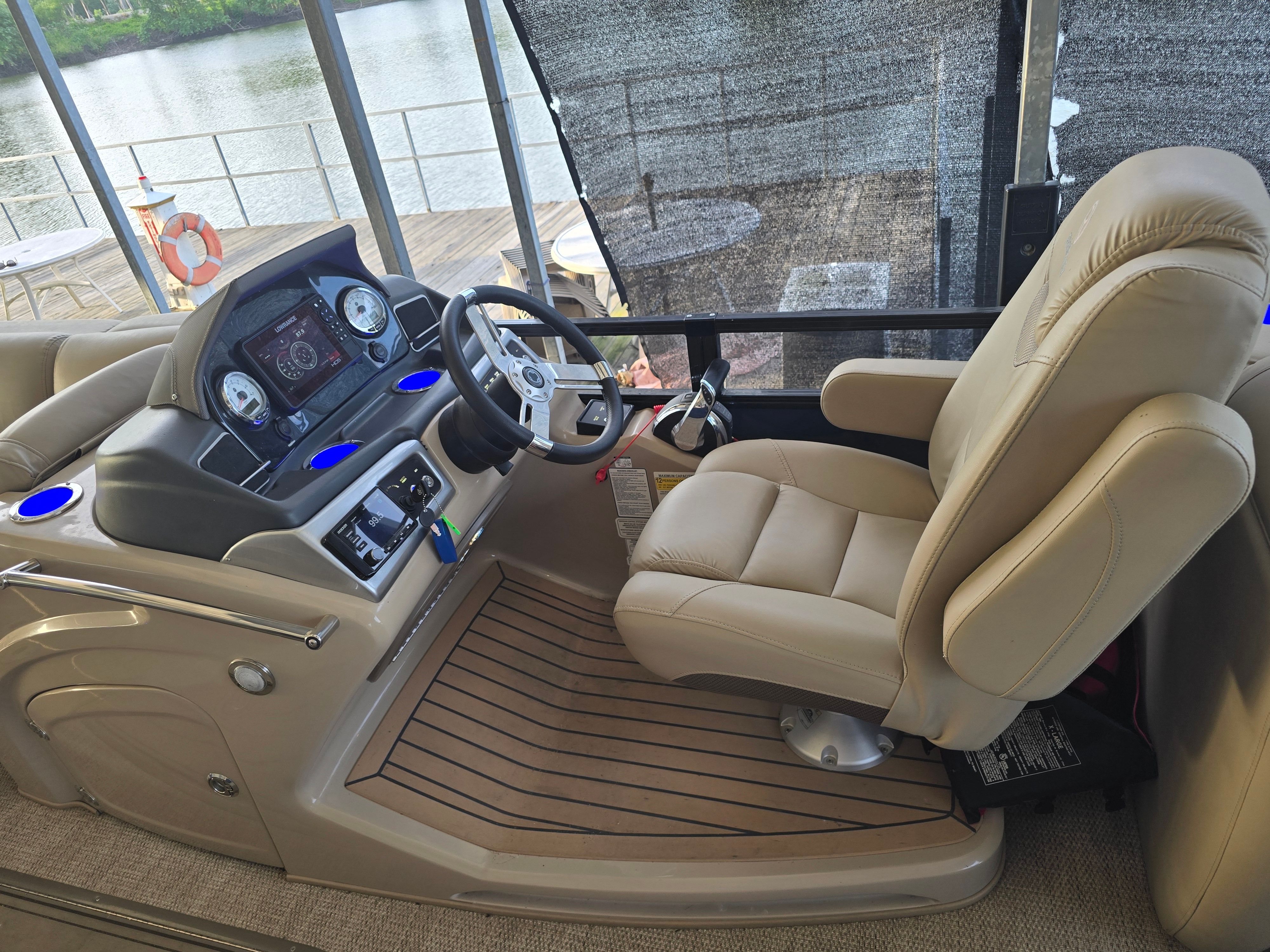 Interior of a 2021 Regency 230 LE3 with beige captain's chair and modern dashboard.