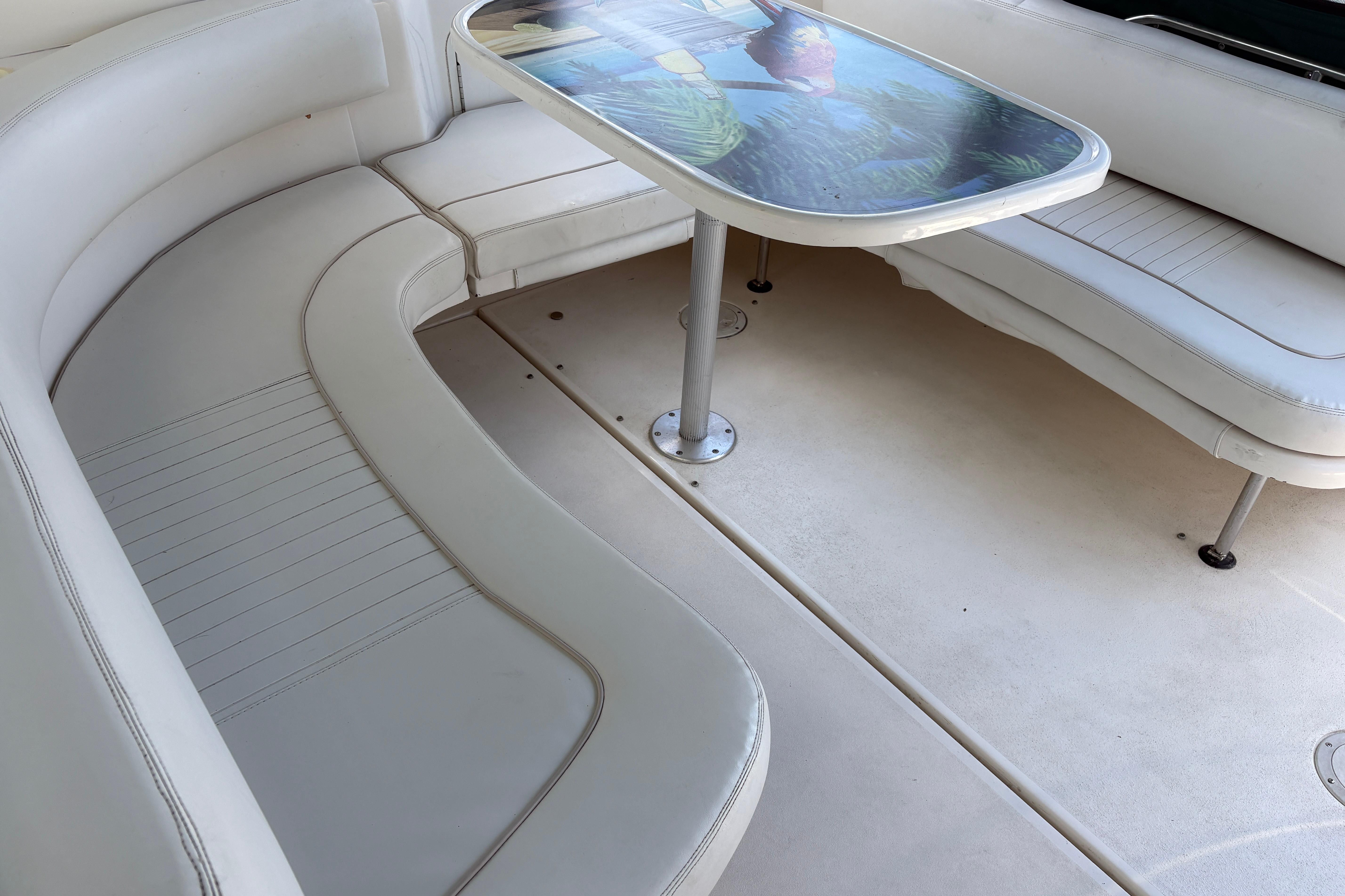 2001 Sea Ray Sundancer 310 interior with white seating and a decorative table.
