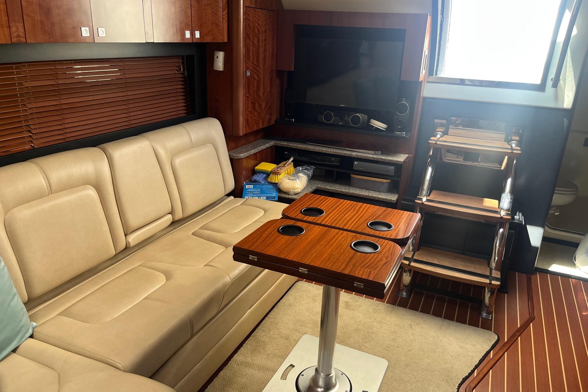 Interior of 2010 Monterey 400 Sport Yacht with beige seating and wooden table.