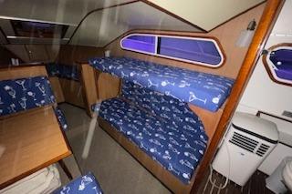 Interior of a 1964 Striker Model 120 boat with blue patterned bunk beds.