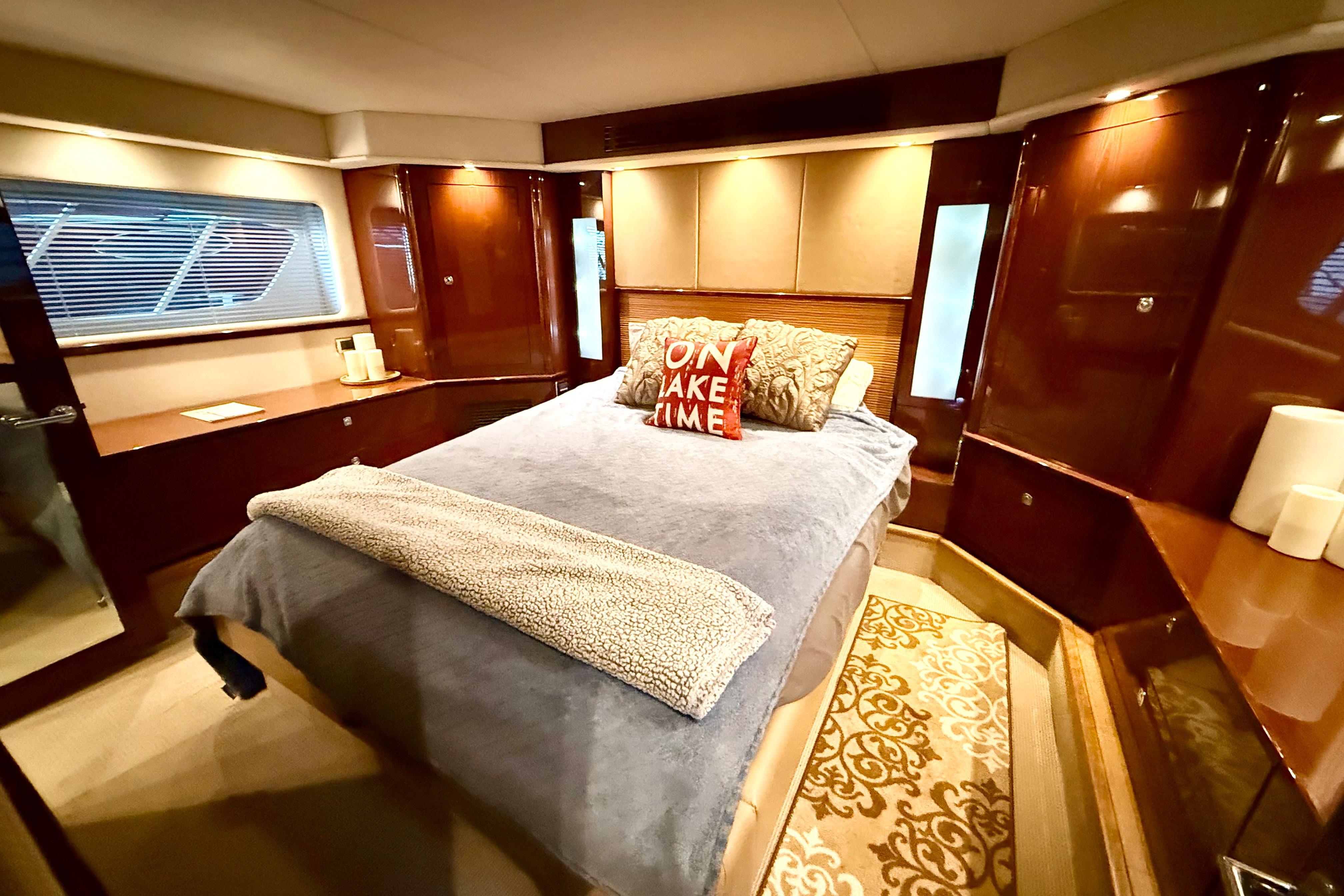 Luxurious bedroom interior of 2014 Sea Ray 580 Sundancer yacht with elegant wood finishes.