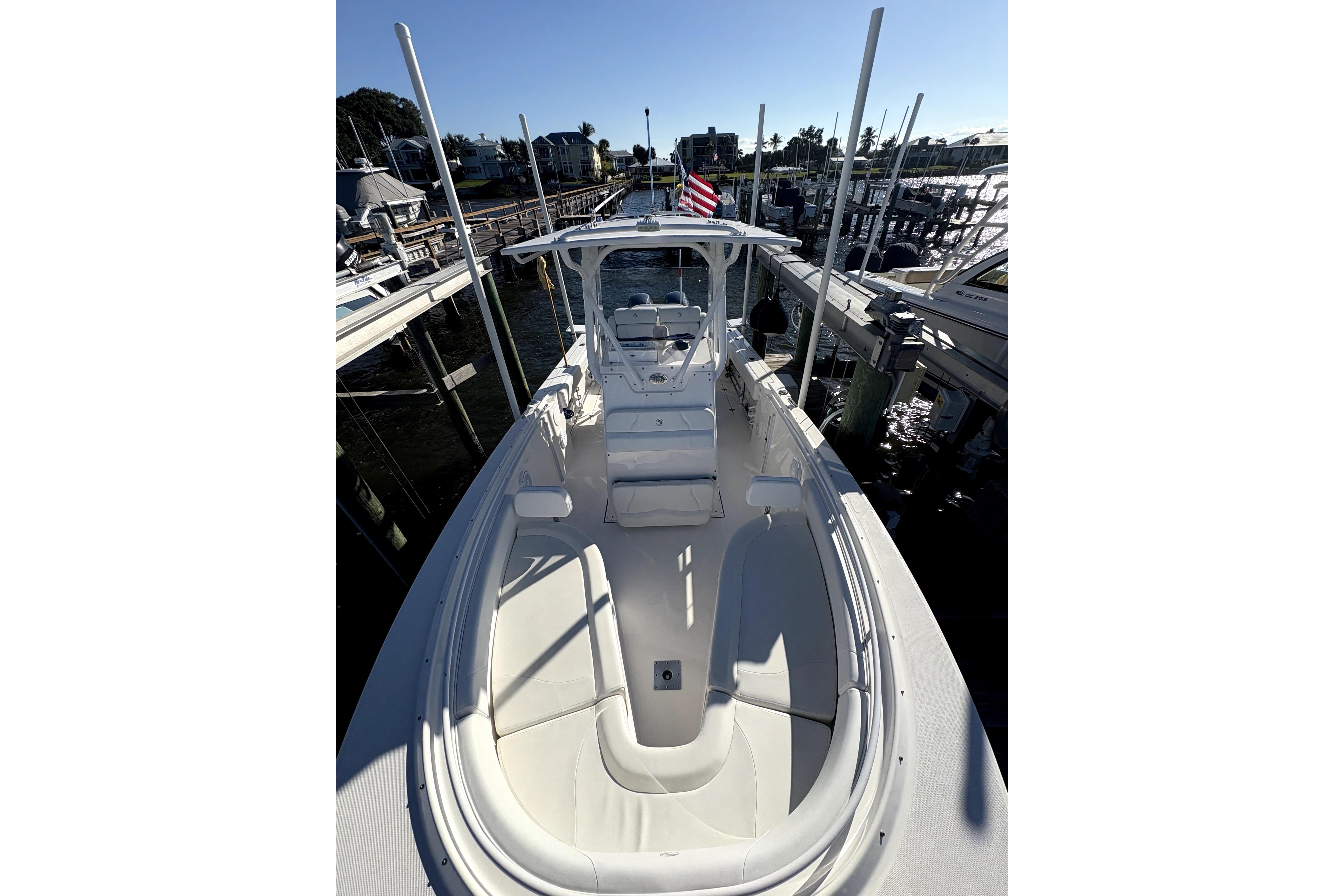 2015 Edgewater 245CC boat docked at marina, featuring spacious deck and seating.