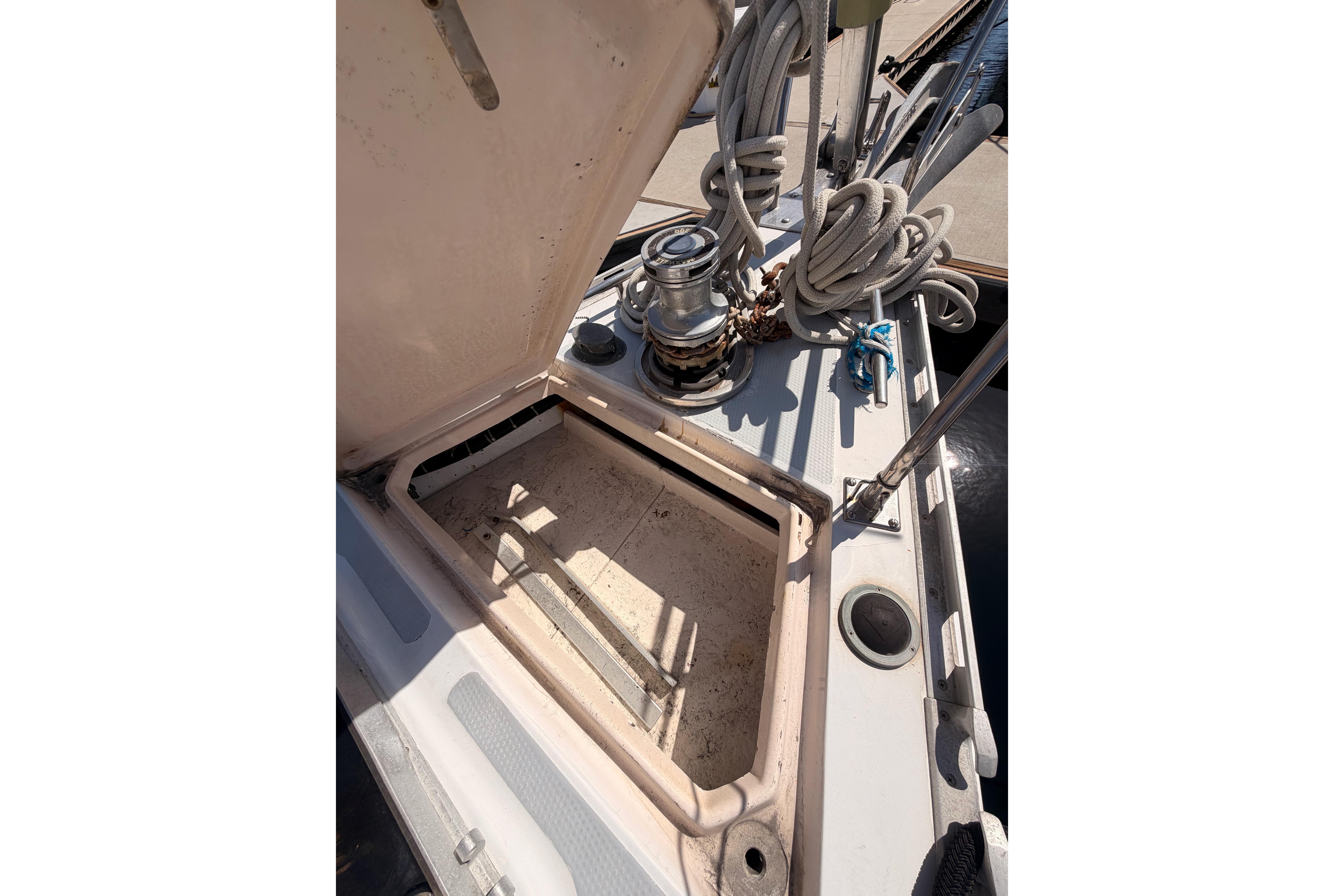 Open hatch on 1991 Hylas 51 sailboat deck with coiled ropes and winch.