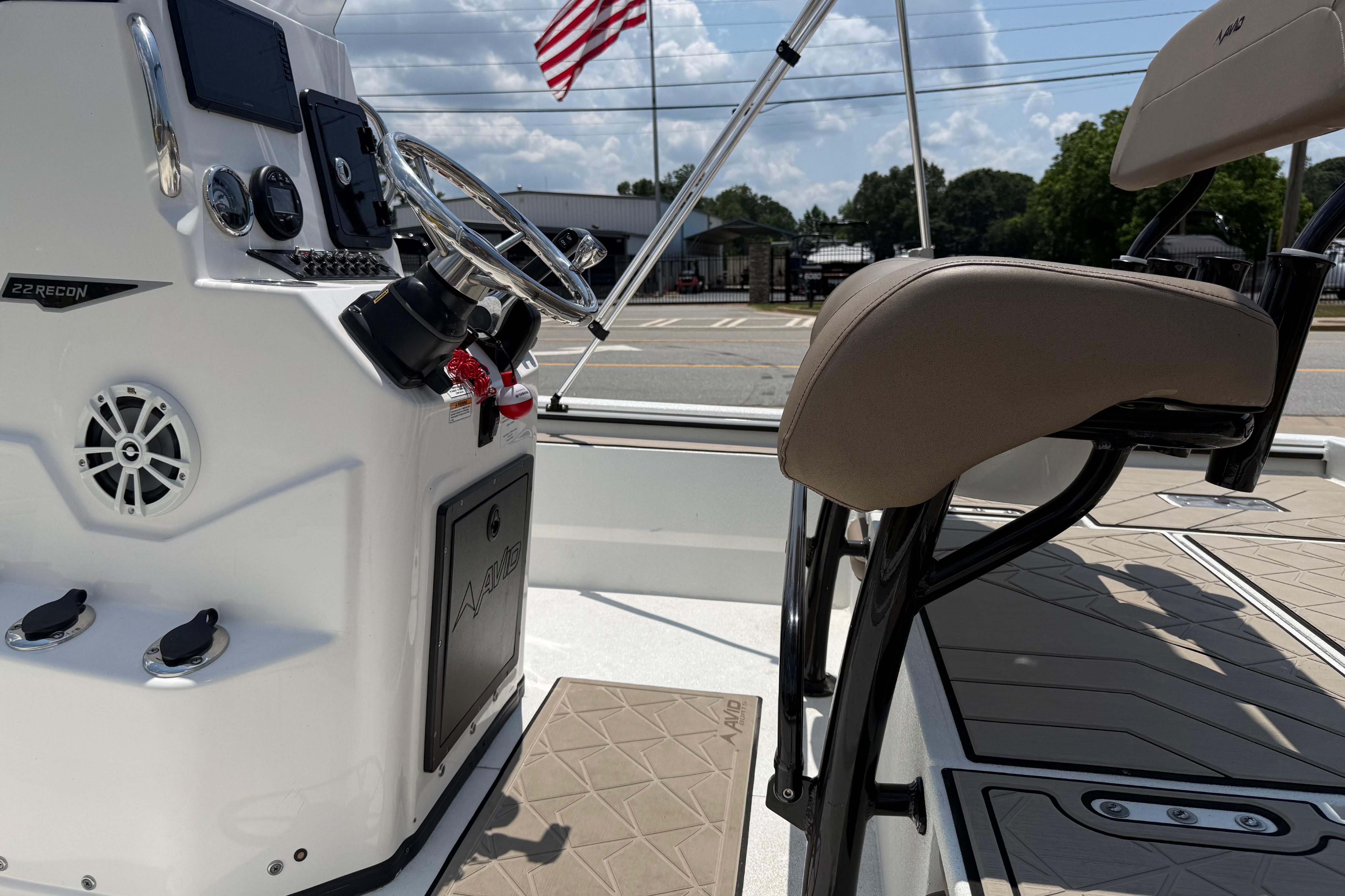 Interior of 2025 Avid 22 Recon boat with steering console and seating.