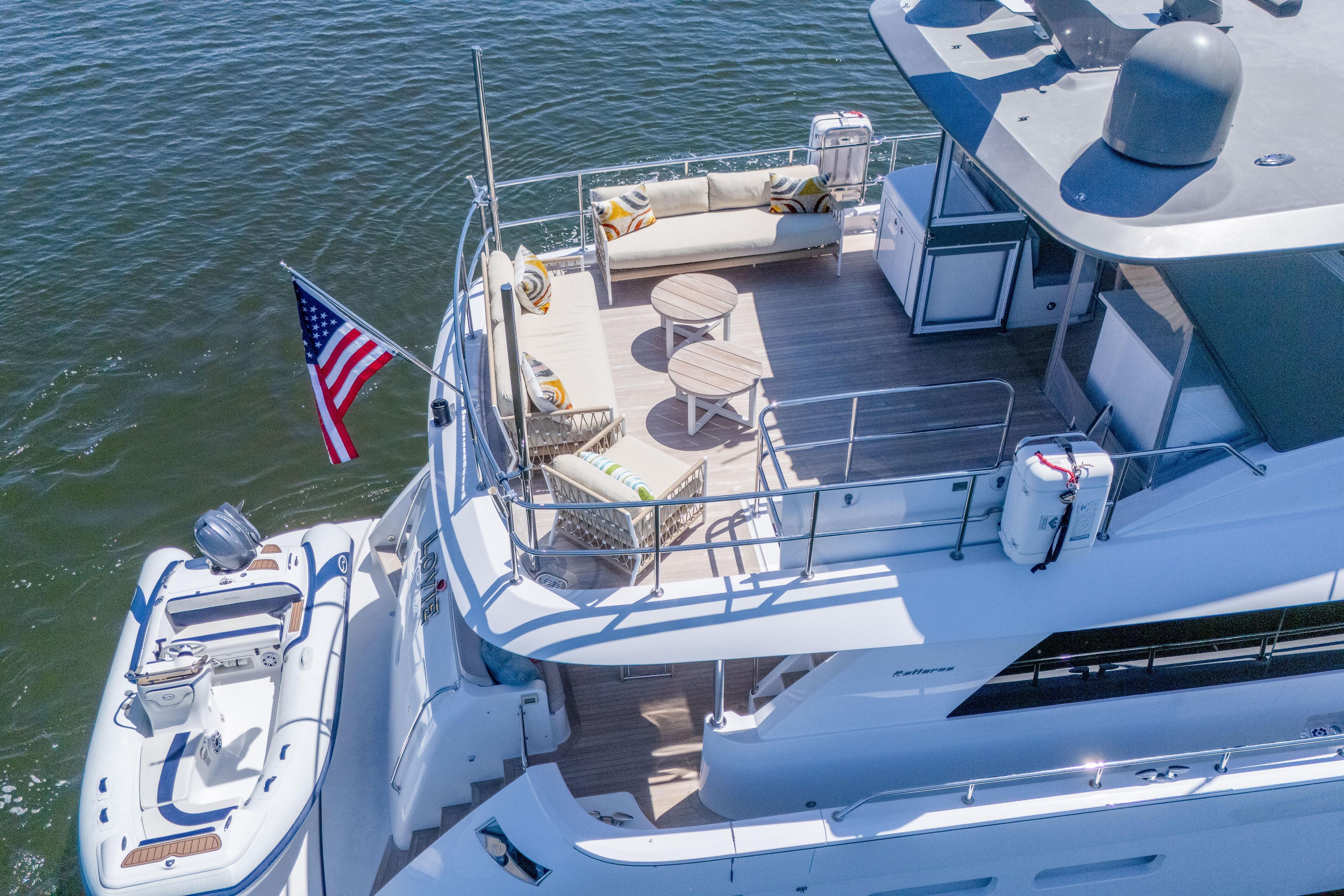 Aerial view of 2021 Hatteras M75 Panacera yacht with deck seating and American flag.