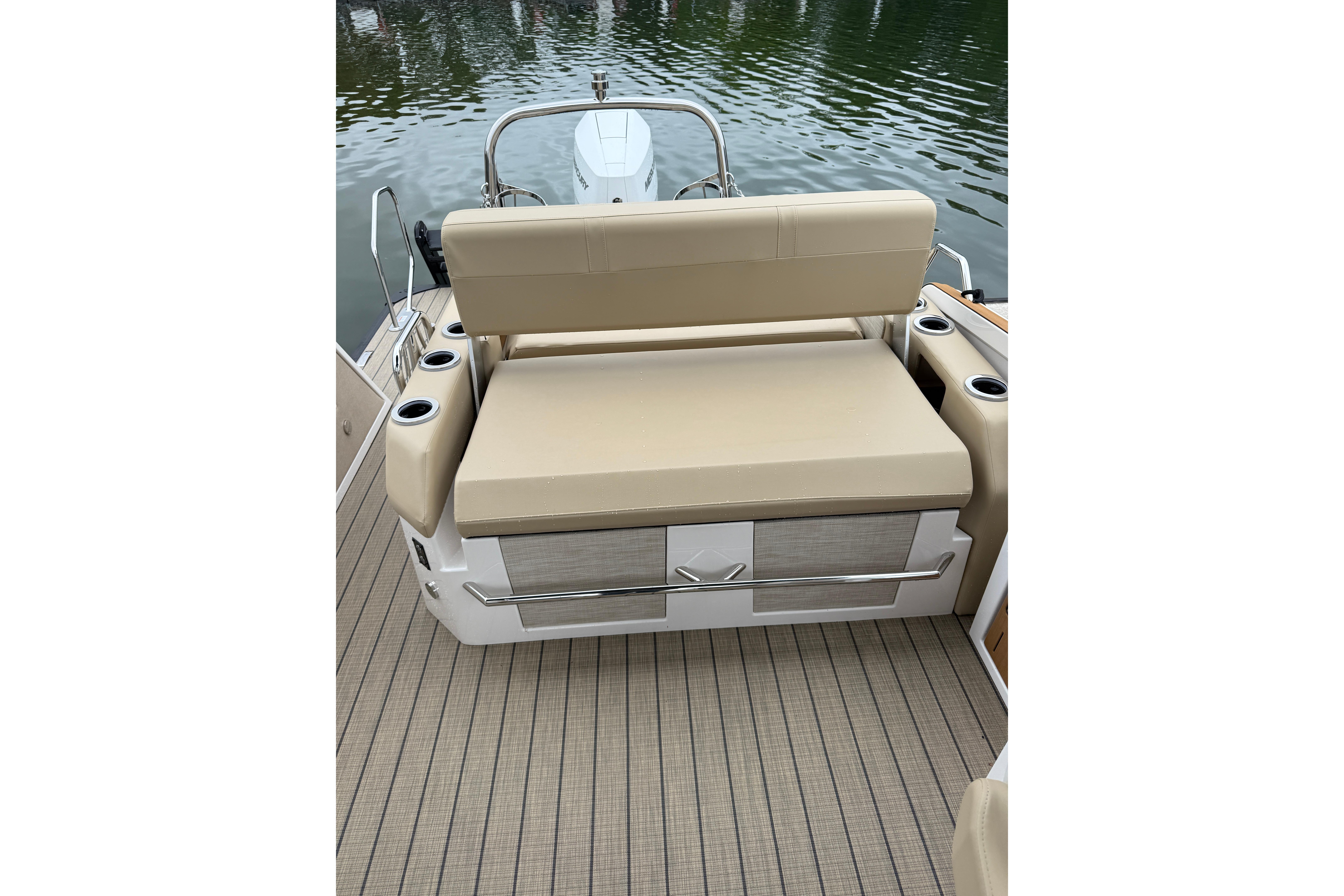 2025 Balise Helix 26 L boat seating area with beige cushions and cup holders.
