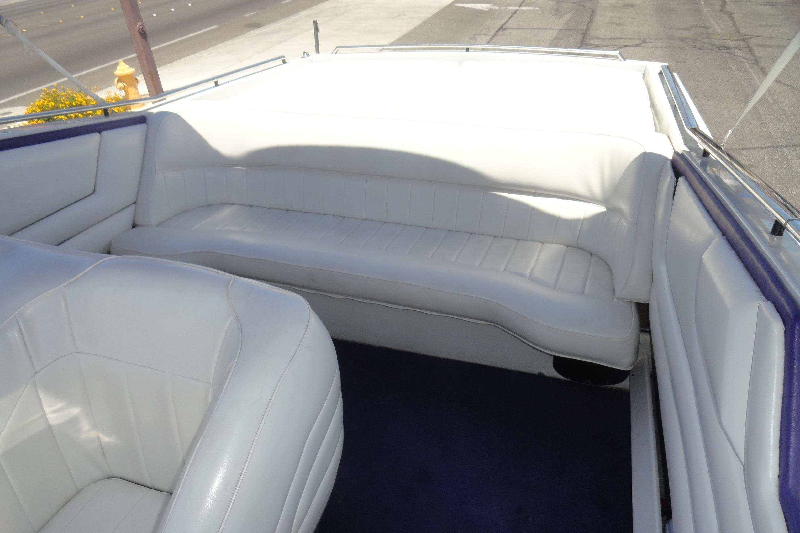 Interior of 1988 Wellcraft 34 Scarab boat with white seating and blue carpet.