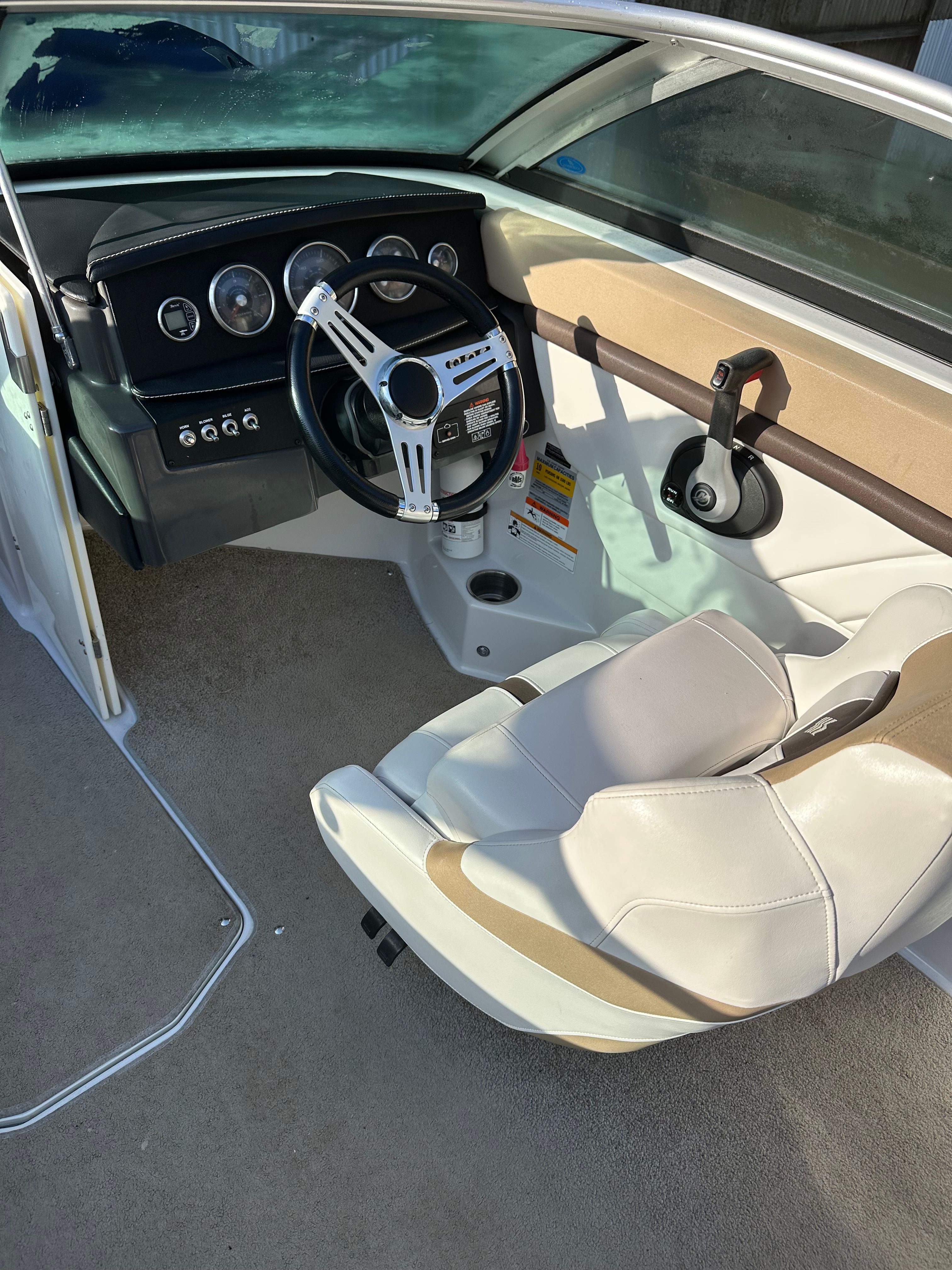 Interior of a 2012 Four Winns H210 boat with steering wheel and seat.