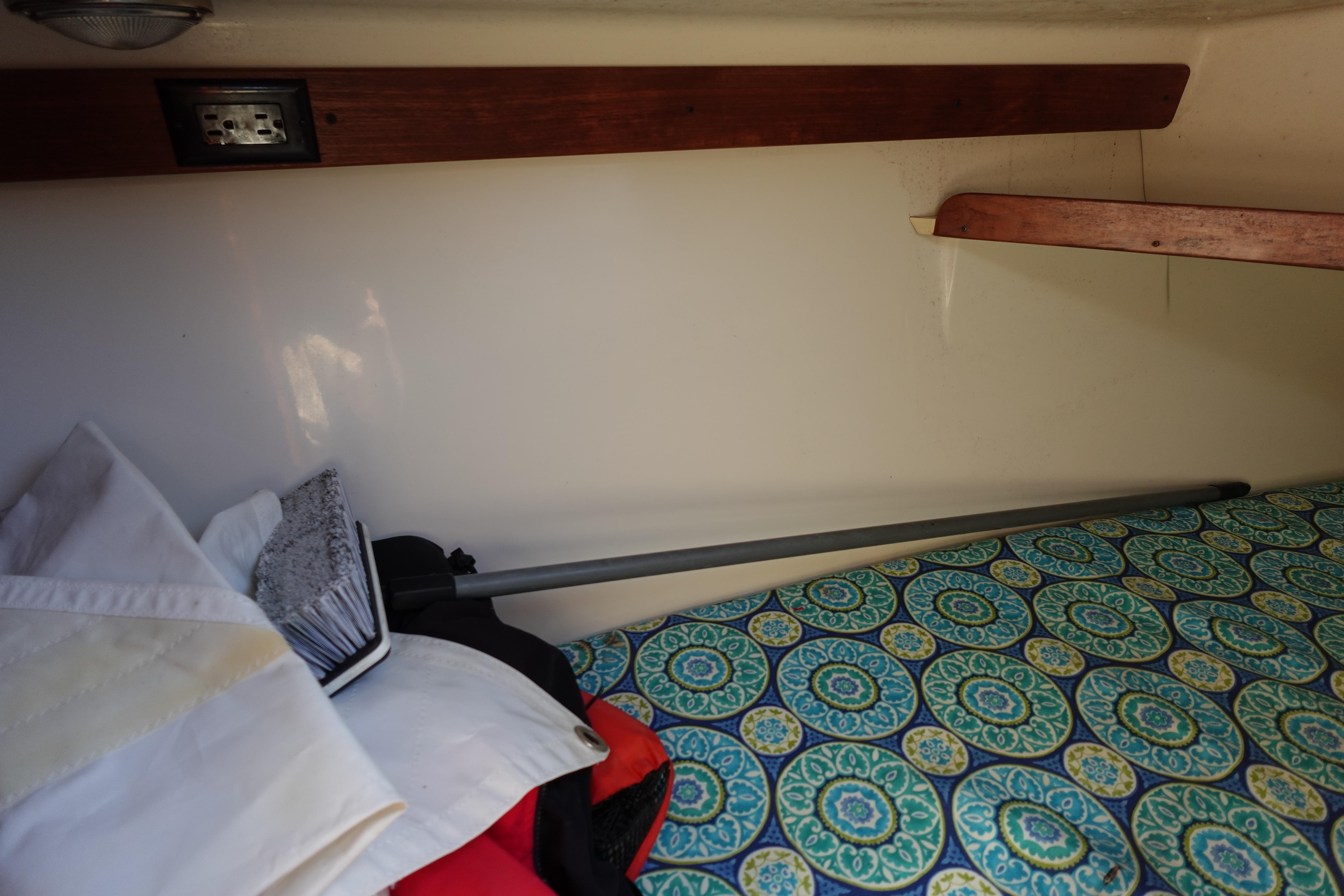 Interior of a 1997 Catalina 28 sailboat with patterned bedding and storage shelves.