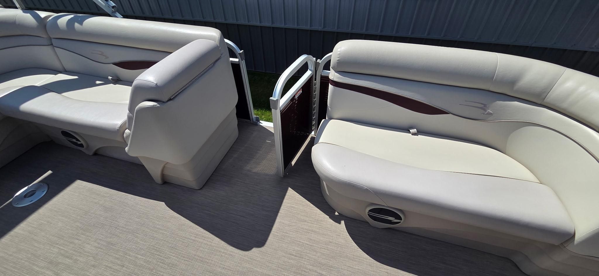 The image shows the interior of a 2018 Bennington 18SL with beige seating and a small gate.