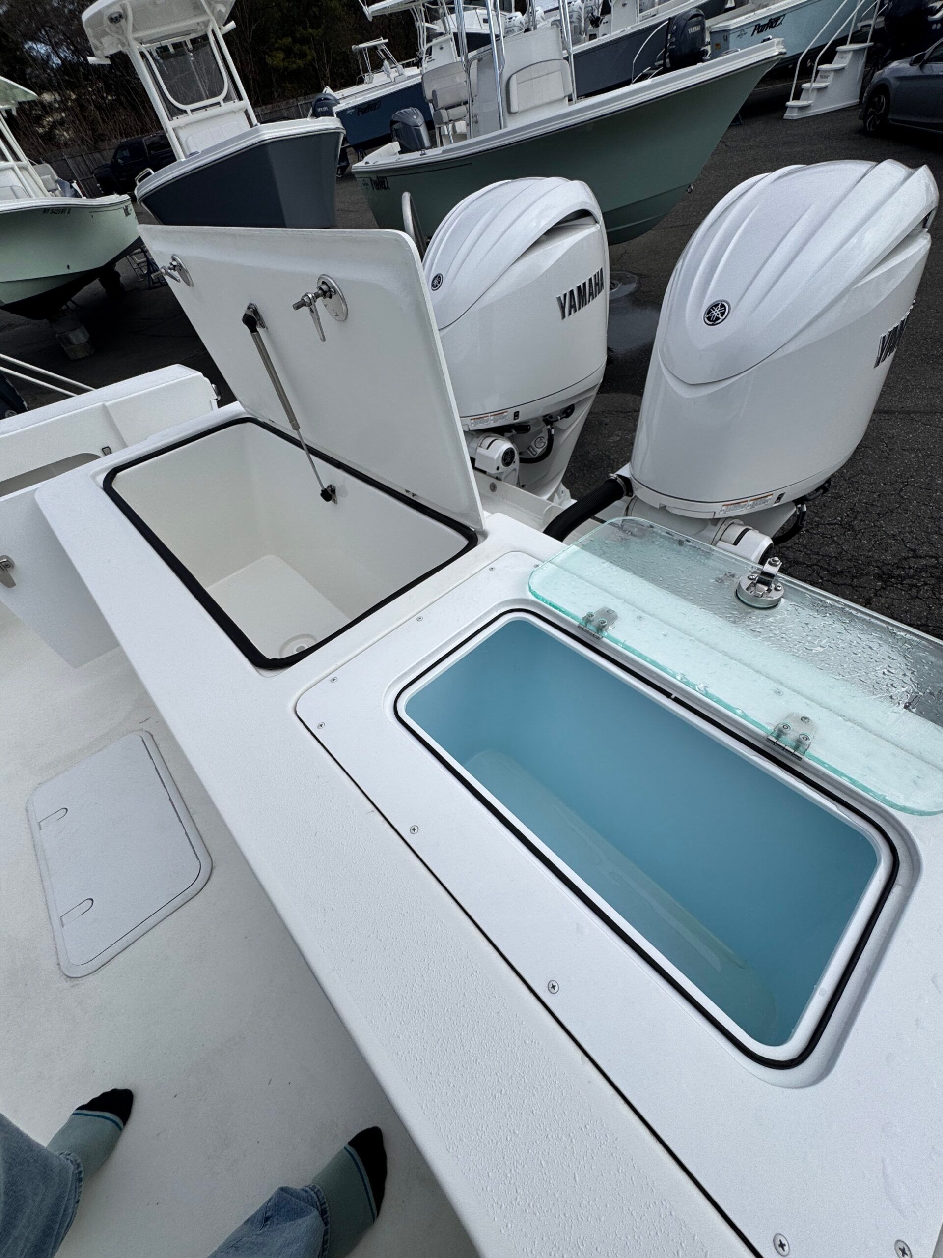 The image shows the stern area of a boat with two Yamaha outboard motors and a blue water tank.