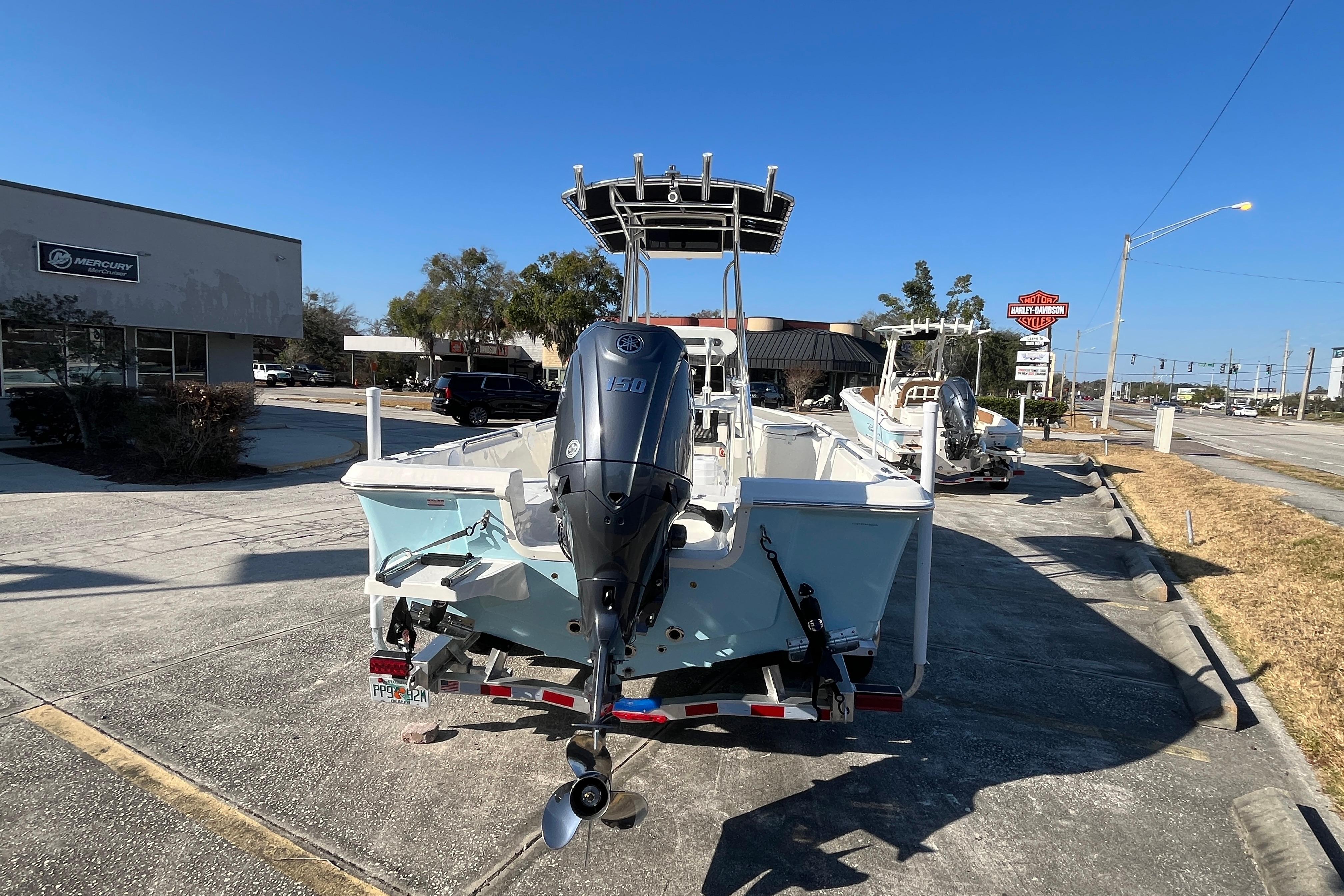 2026 Bulls Bay 2200 boat with outboard motor on trailer, parked near dealership.