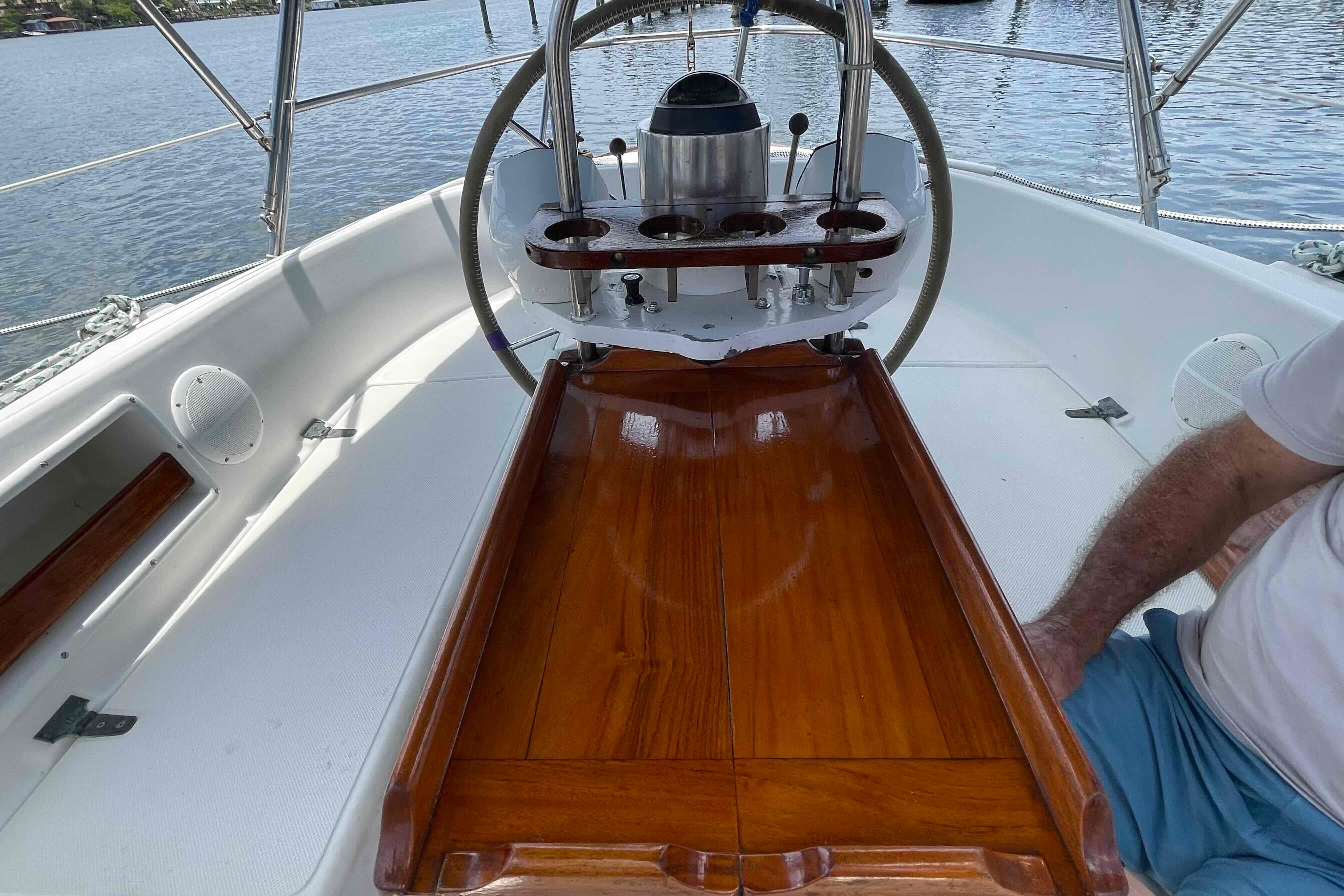 Cockpit of 1987 Pacific Seacraft 34 sailboat with polished wood table and steering wheel.