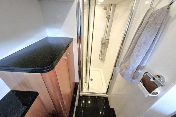 Luxurious bathroom in 2005 Sunseeker Manhattan 66 yacht with sleek shower and elegant cabinetry.