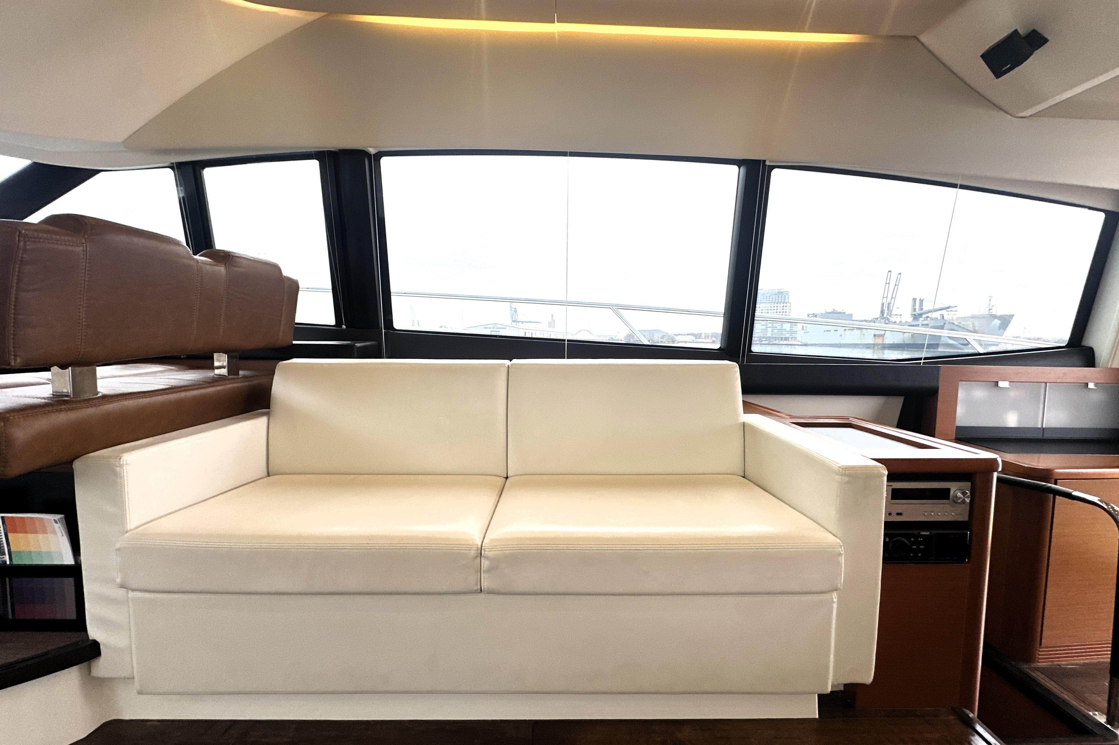 Luxurious interior of 2017 Prestige 500 yacht with white leather seating and panoramic windows.