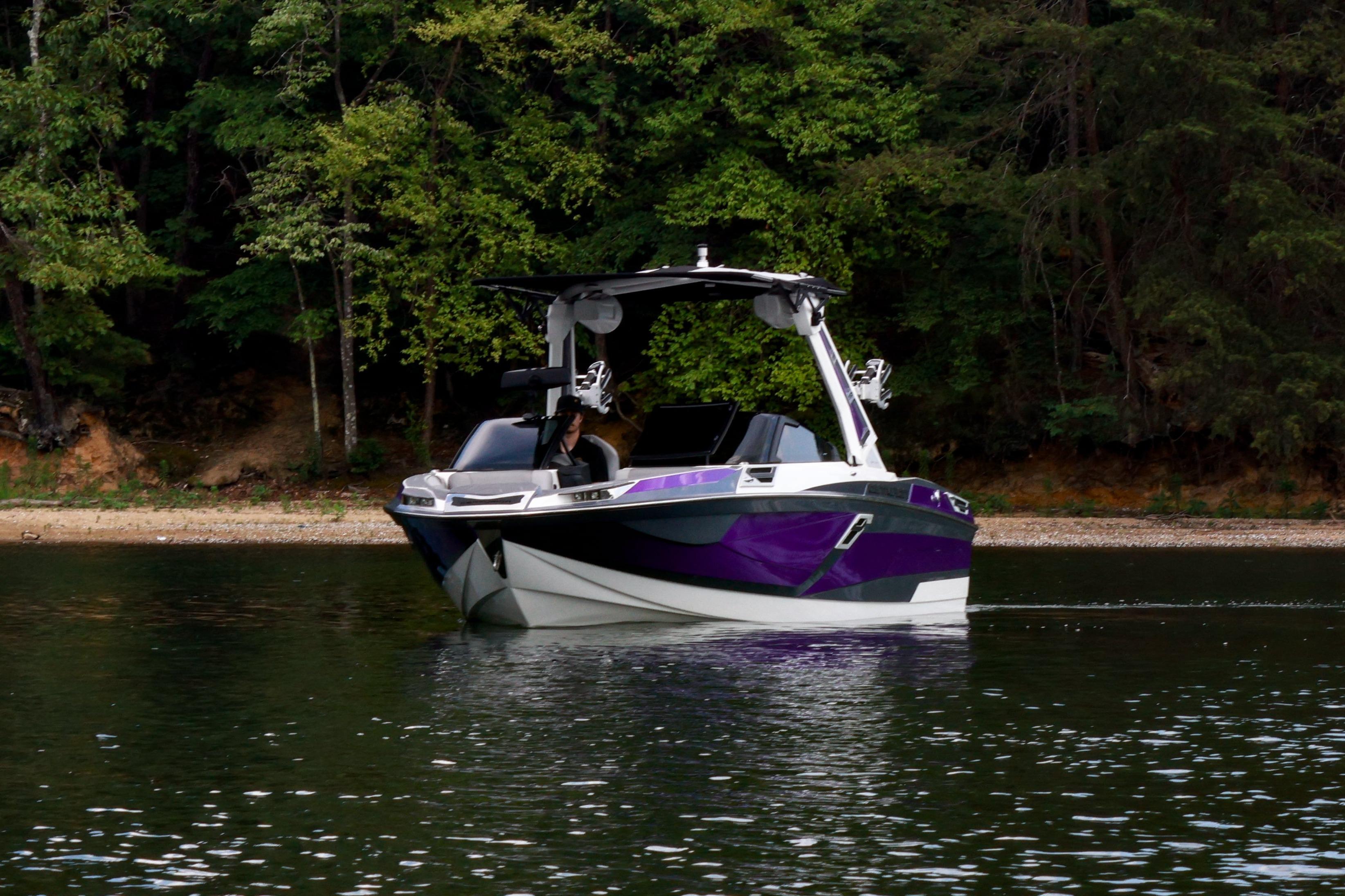 2022 Centurion Ri245 boat on calm water, surrounded by lush green trees.