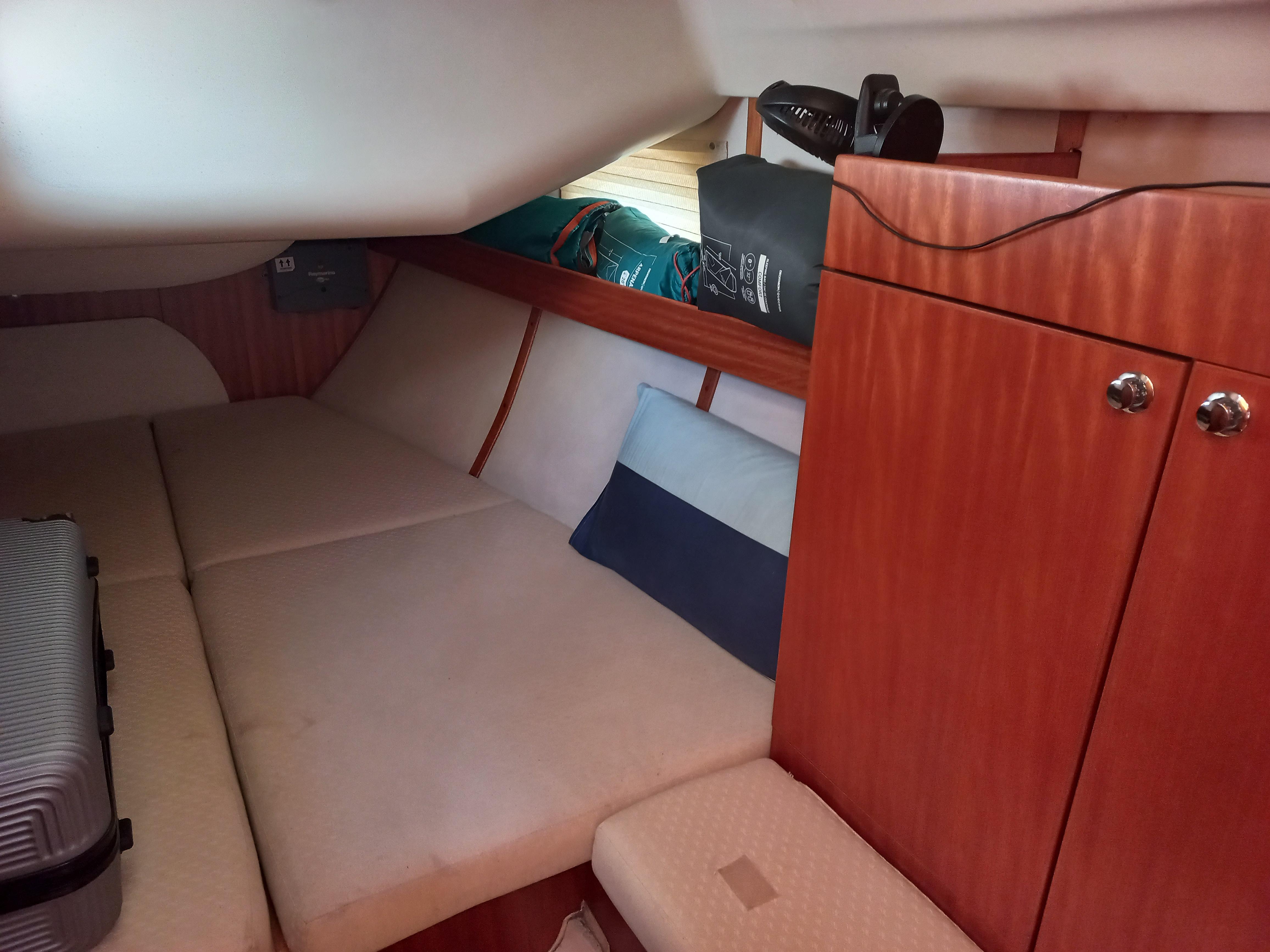 Cozy cabin interior of 2005 Elan Impression 434 sailboat with wooden cabinetry and cushioned seating.