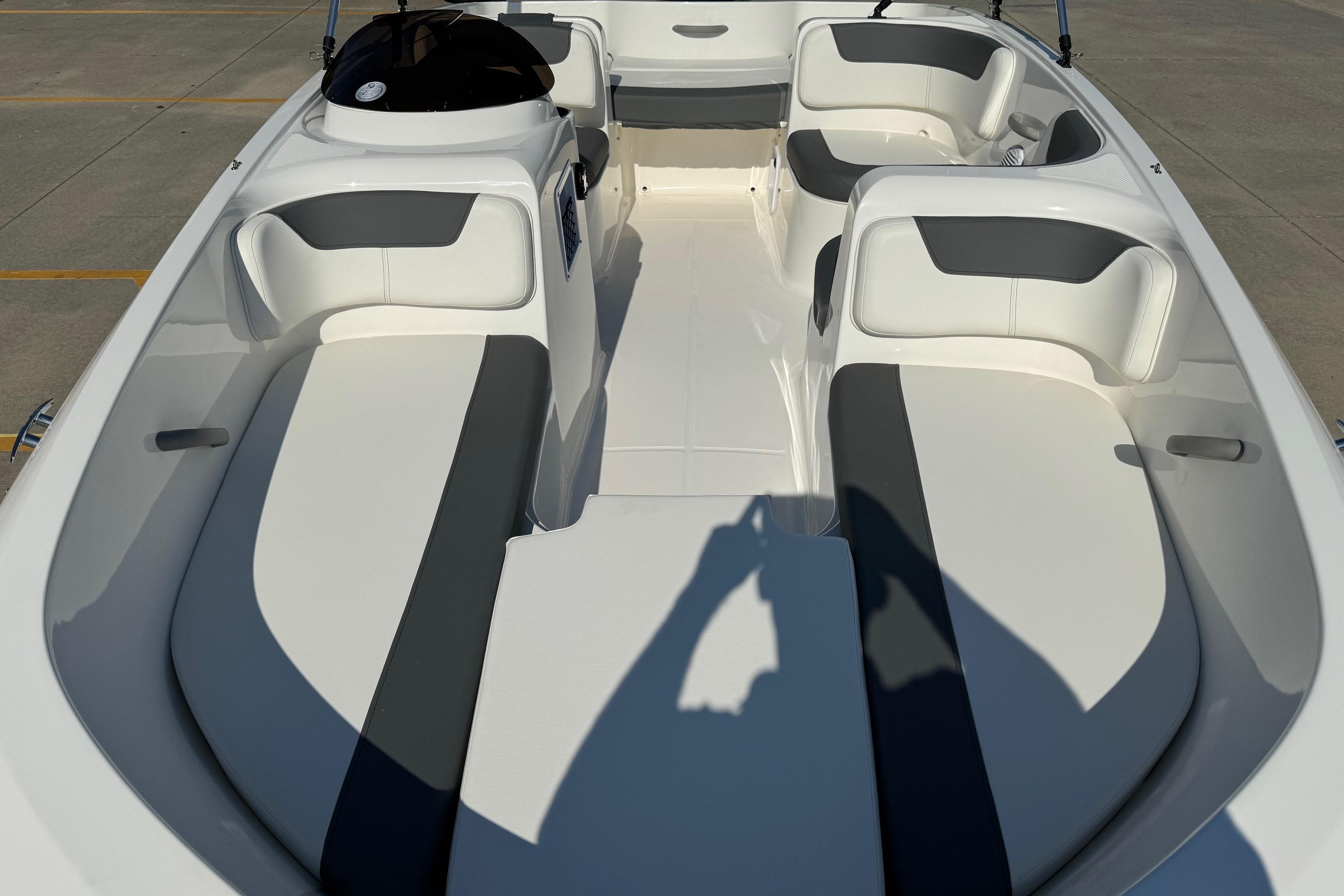 2025 Bayliner Element E16 boat interior with white and gray seating, docked on concrete.