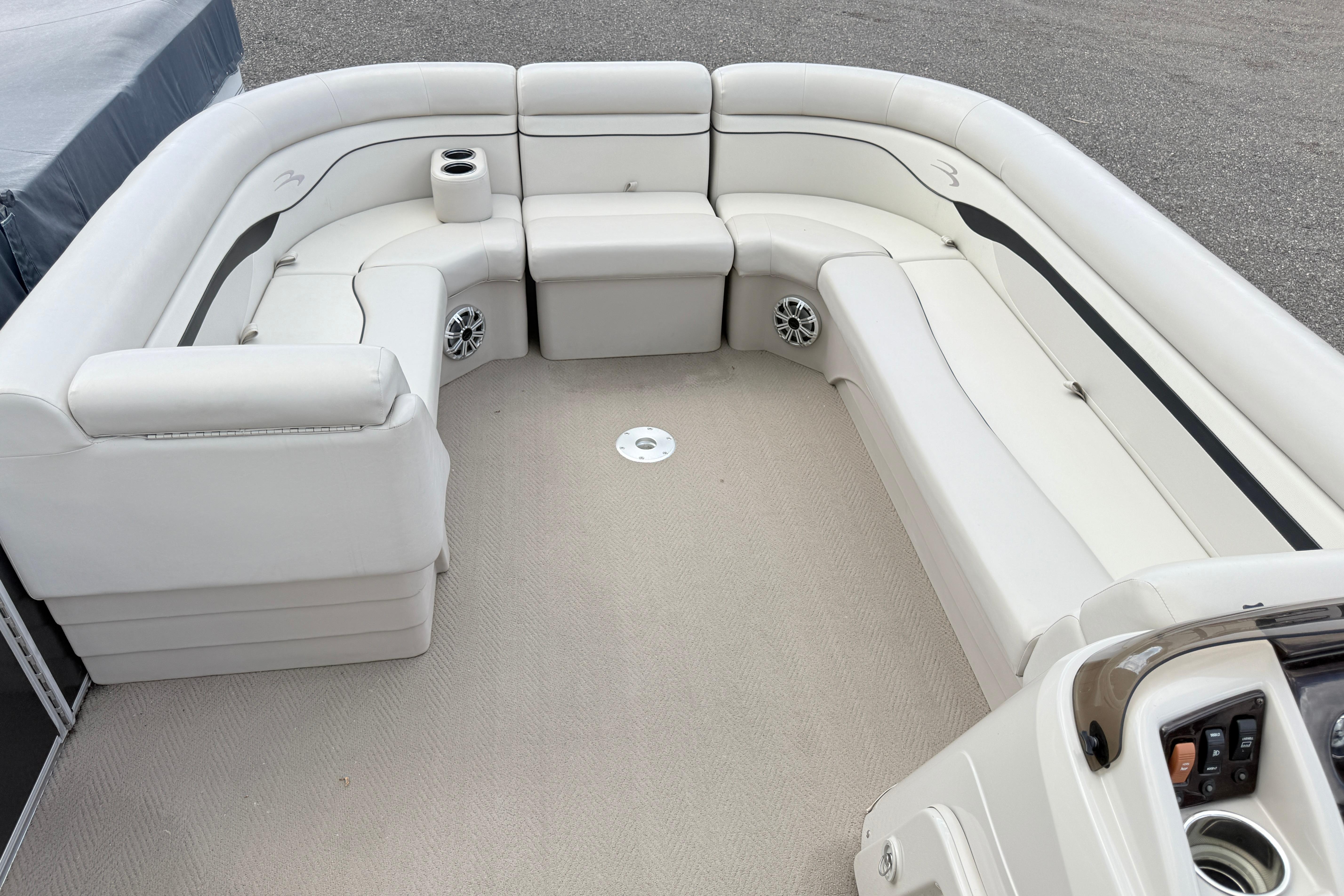 2015 Bennington 24SSLX pontoon boat interior with white seating and cup holders.