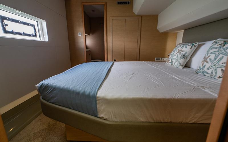 Luxurious bedroom interior of 2018 Fountaine Pajot MY44 yacht with modern design and cozy bedding.