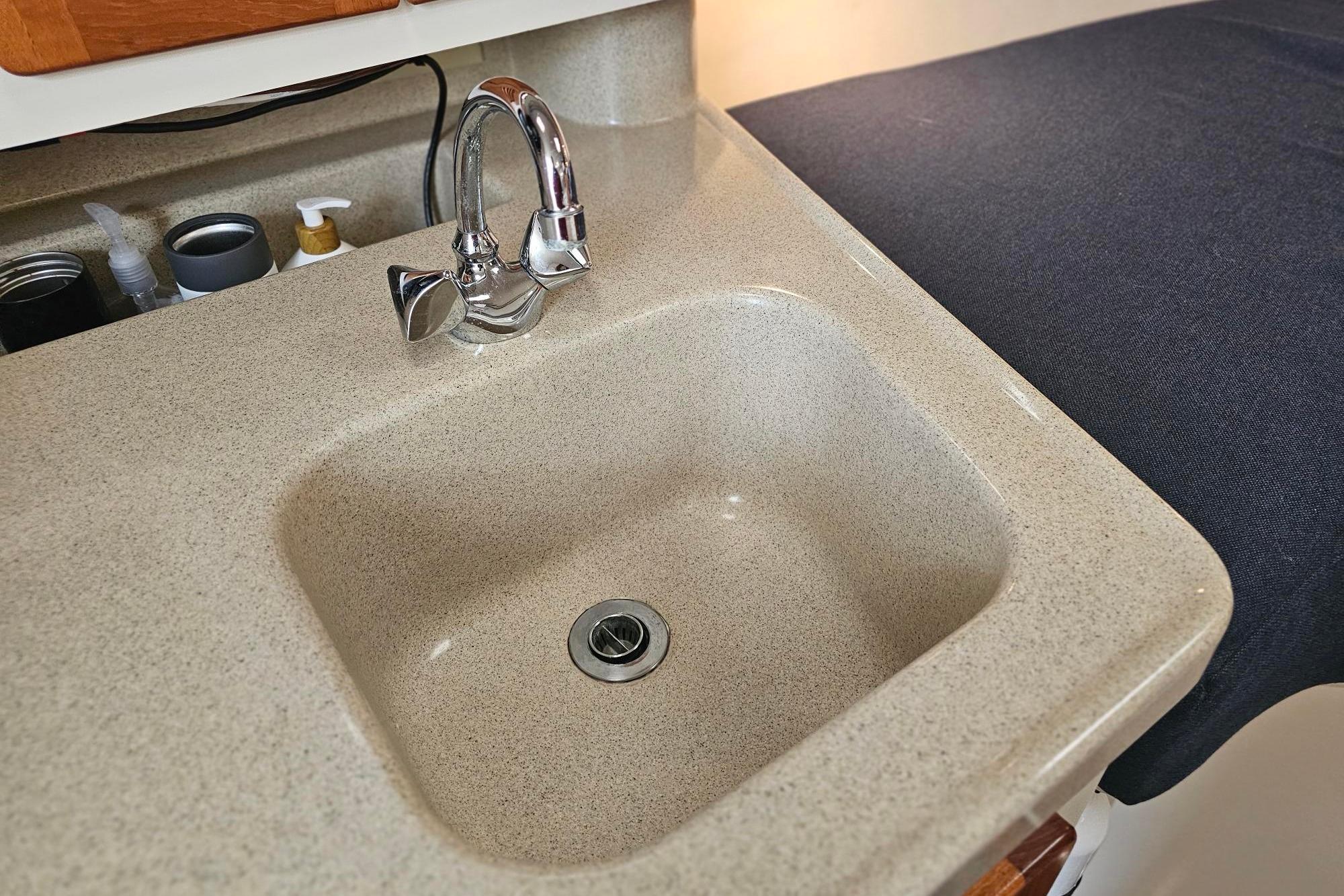 2001 Pursuit 3000 Express boat interior sink with chrome faucet and countertop.