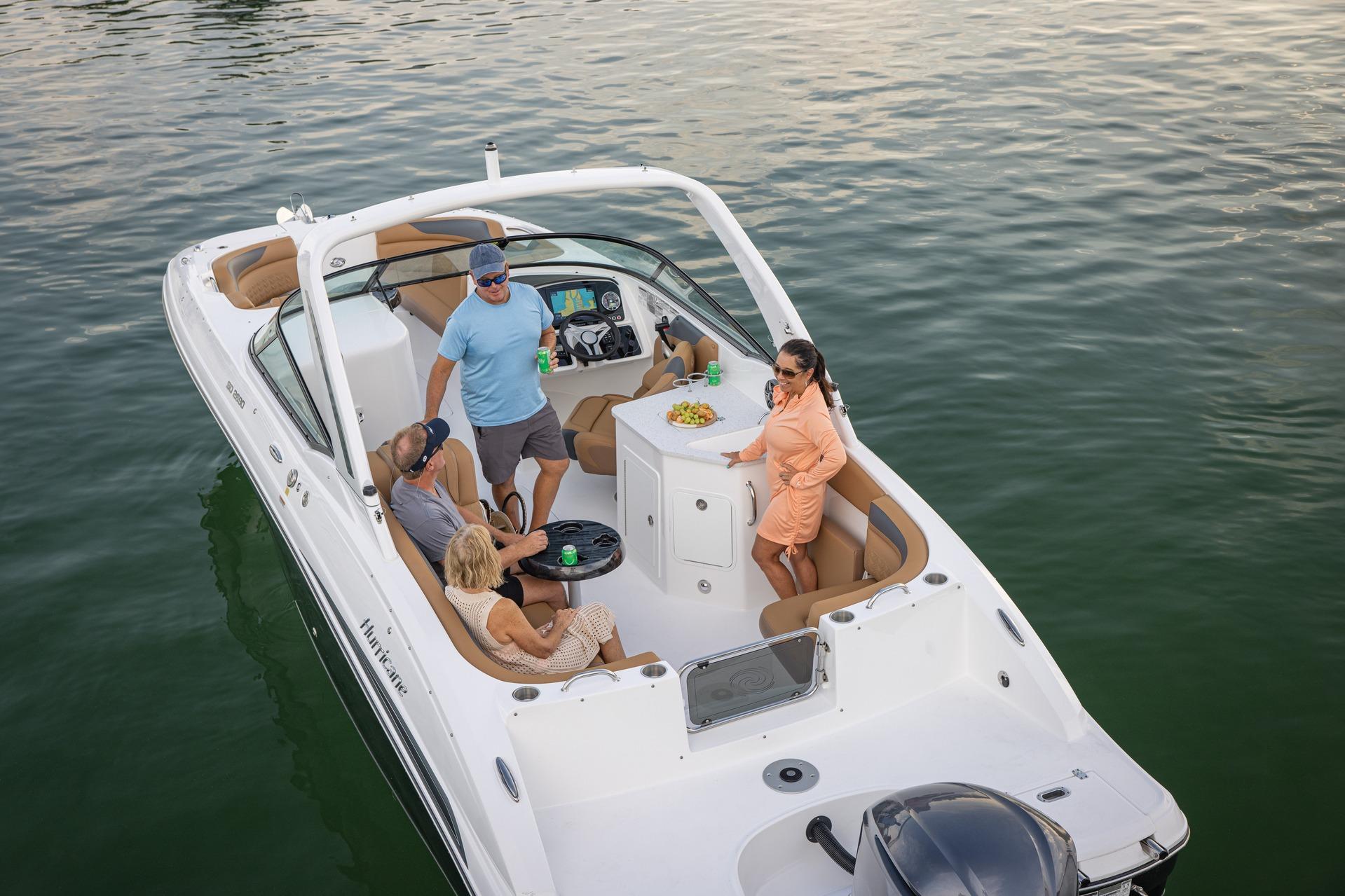 2026 Hurricane SunDeck 2690 OB boat with people enjoying a day on the water.