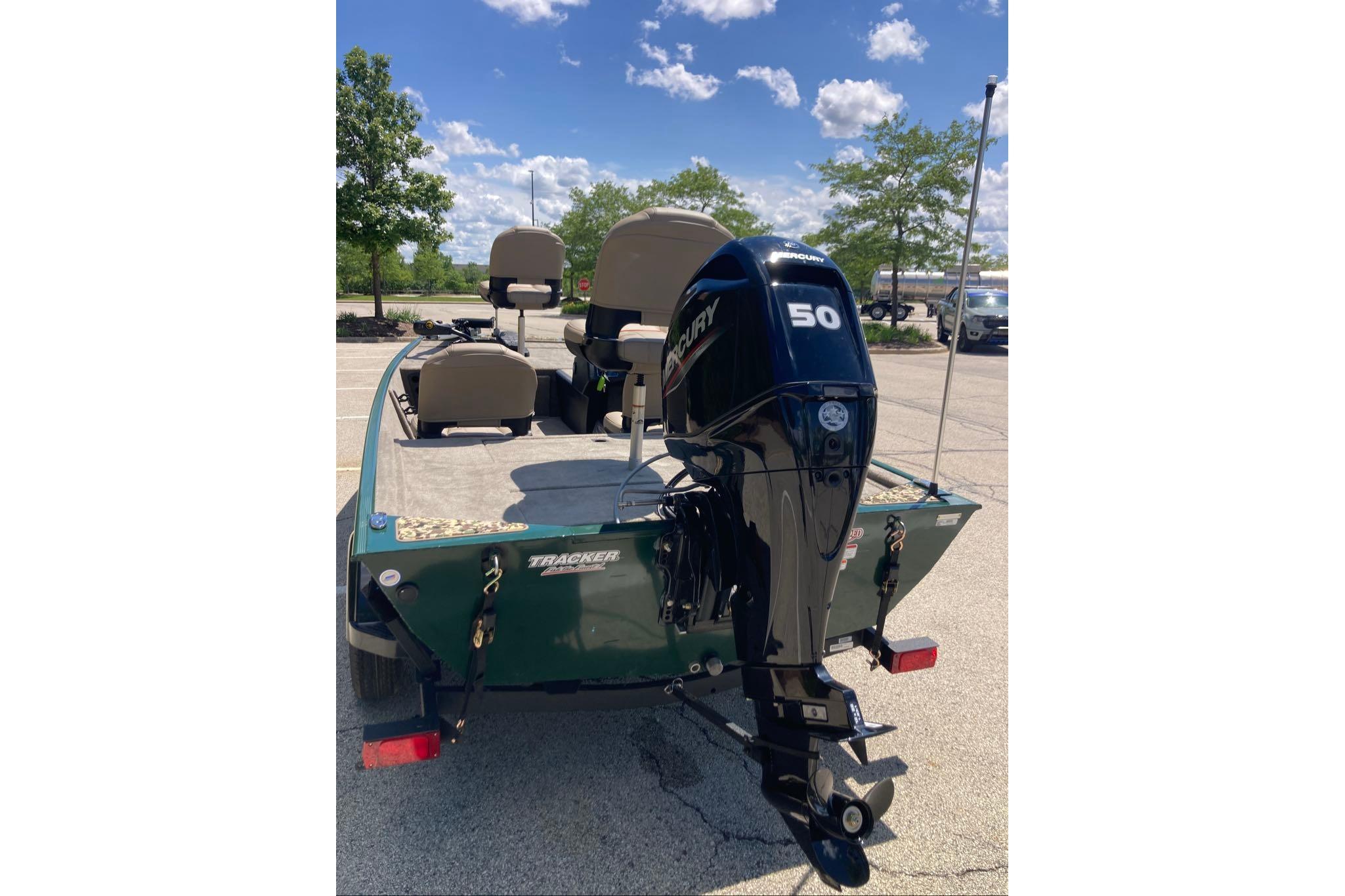 2026 Tracker Bass Tracker Classic Limited boat with Mercury 50 engine in parking lot.