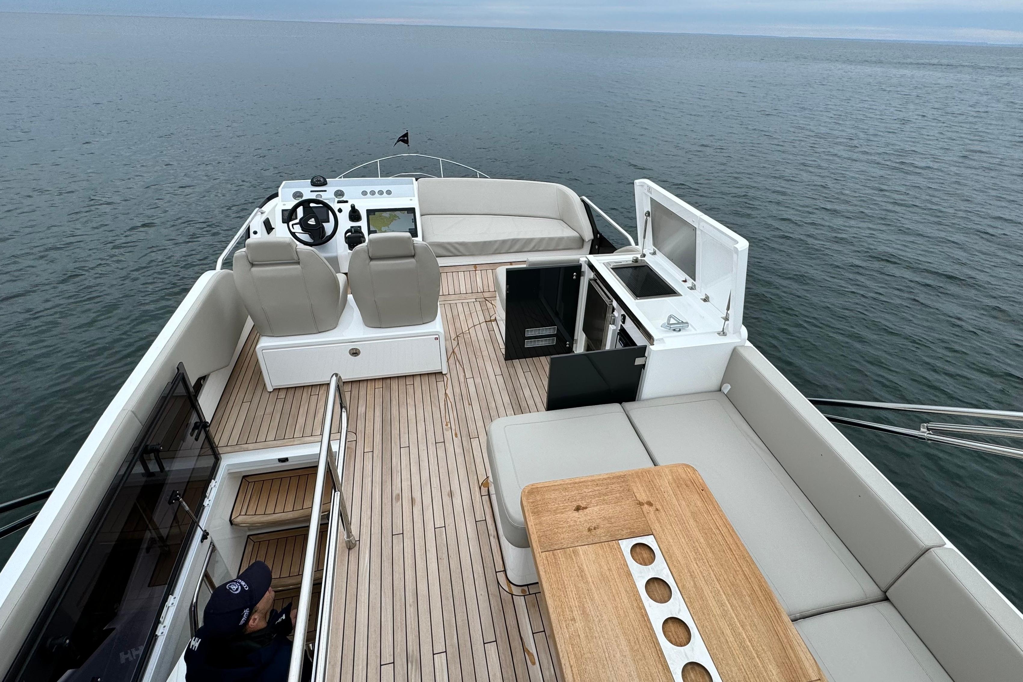 2024 Fairline Squadron 50 yacht deck with seating, helm, and ocean view.