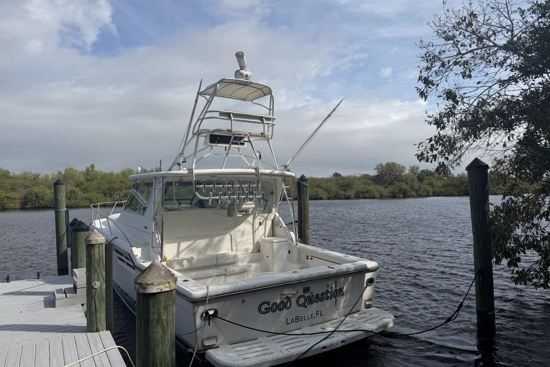 2000 Tiara Yachts 4100 Open docked by a serene riverbank under cloudy skies.