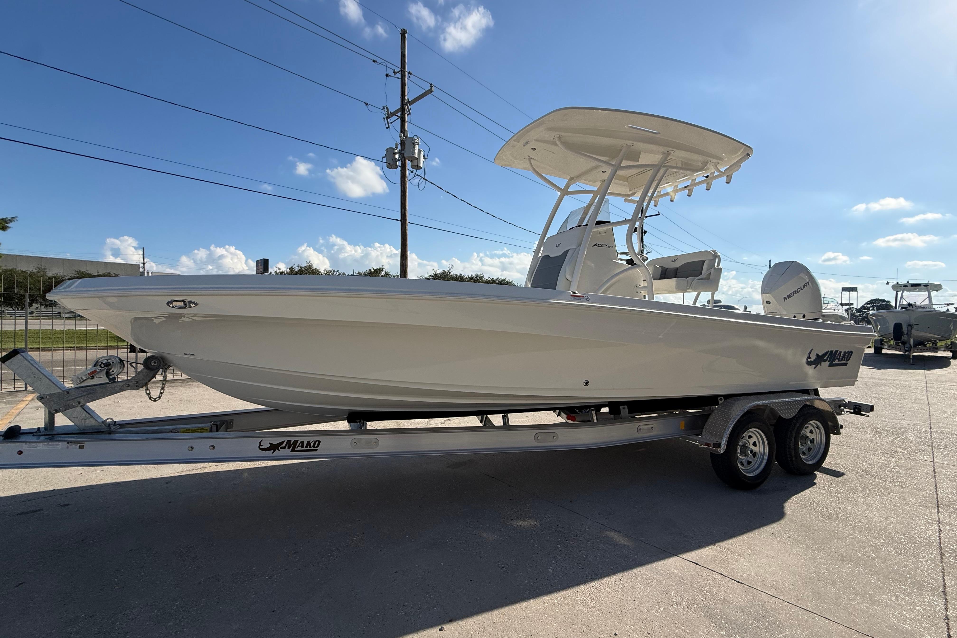 2026 Mako 24 APEX boat on trailer under clear blue sky.