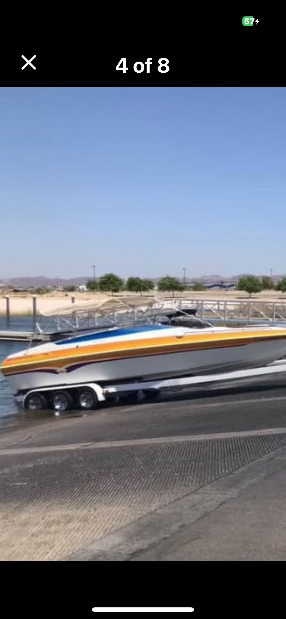 A 2001 Advantage 27 Victory boat being launched into the water on a trailer.