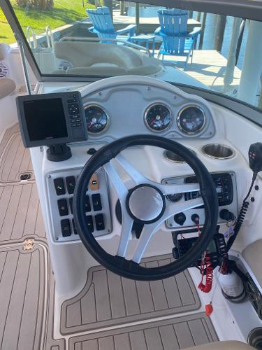 2015 Hurricane SunDeck 2400 OB boat dashboard with steering wheel and navigation controls.