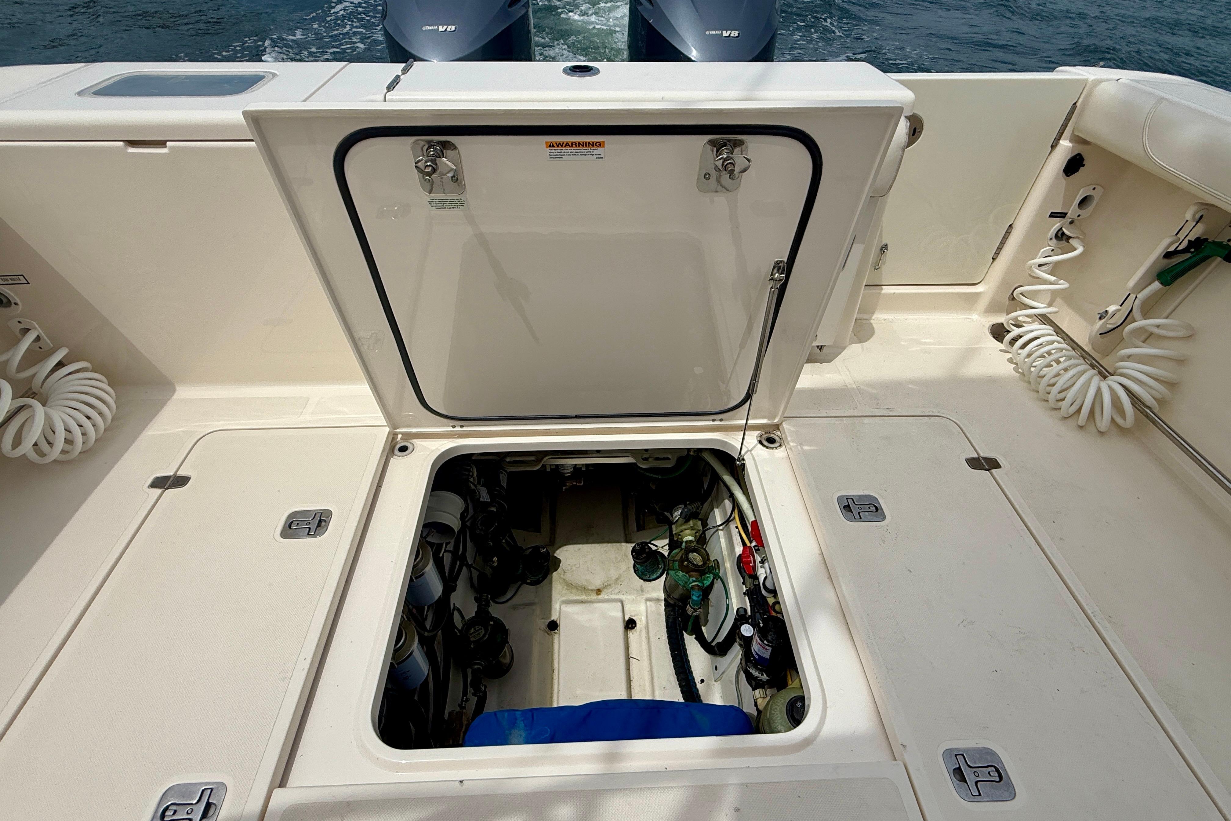 Open hatch on 2012 Pursuit OS 345 Offshore boat, revealing engine compartment.