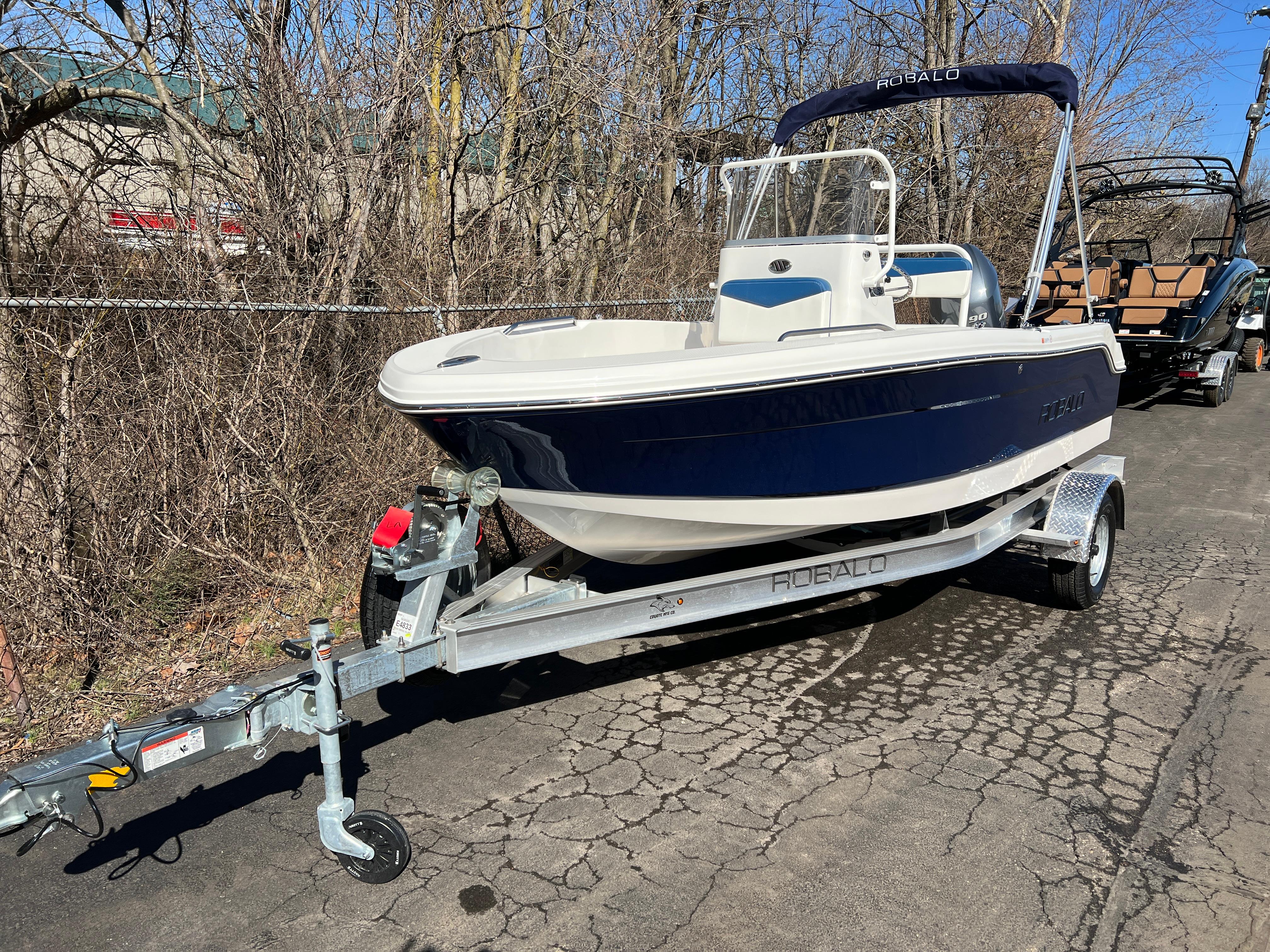 2025 Robalo R160 Center Console boat on trailer, parked outdoors.
