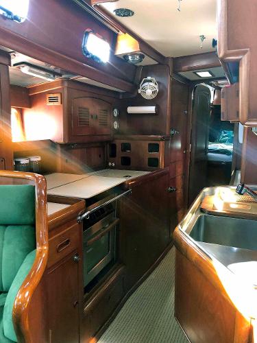 Interior of a 1988 Little Harbor 53 with wood finish and kitchen area.
