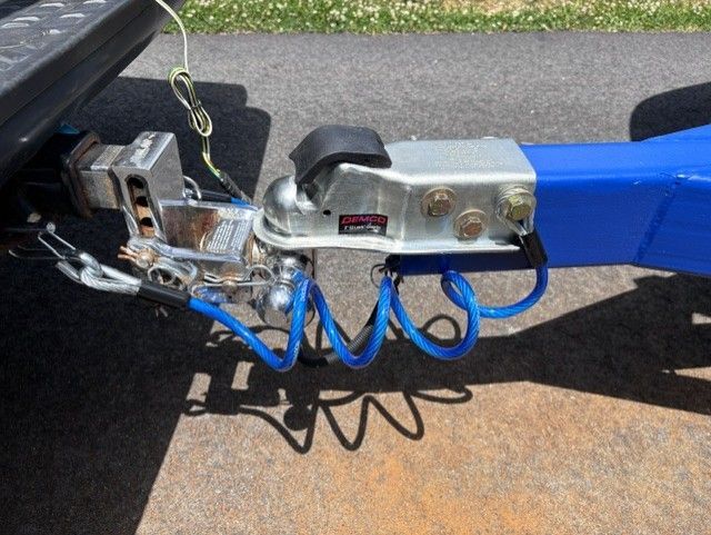 Close-up of a trailer hitch with blue cables.