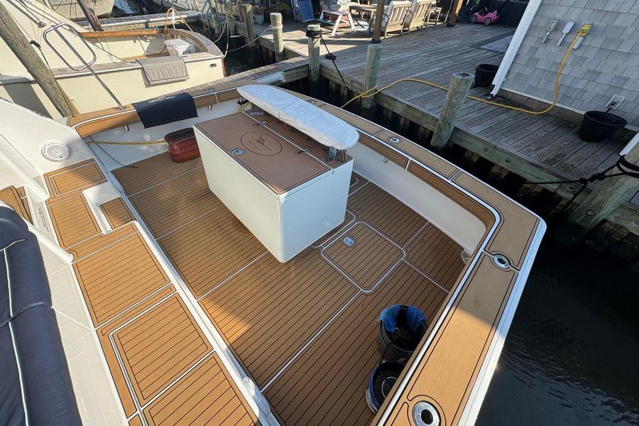 2002 Viking 61 Enclosed Bridge yacht with teak deck at dock.