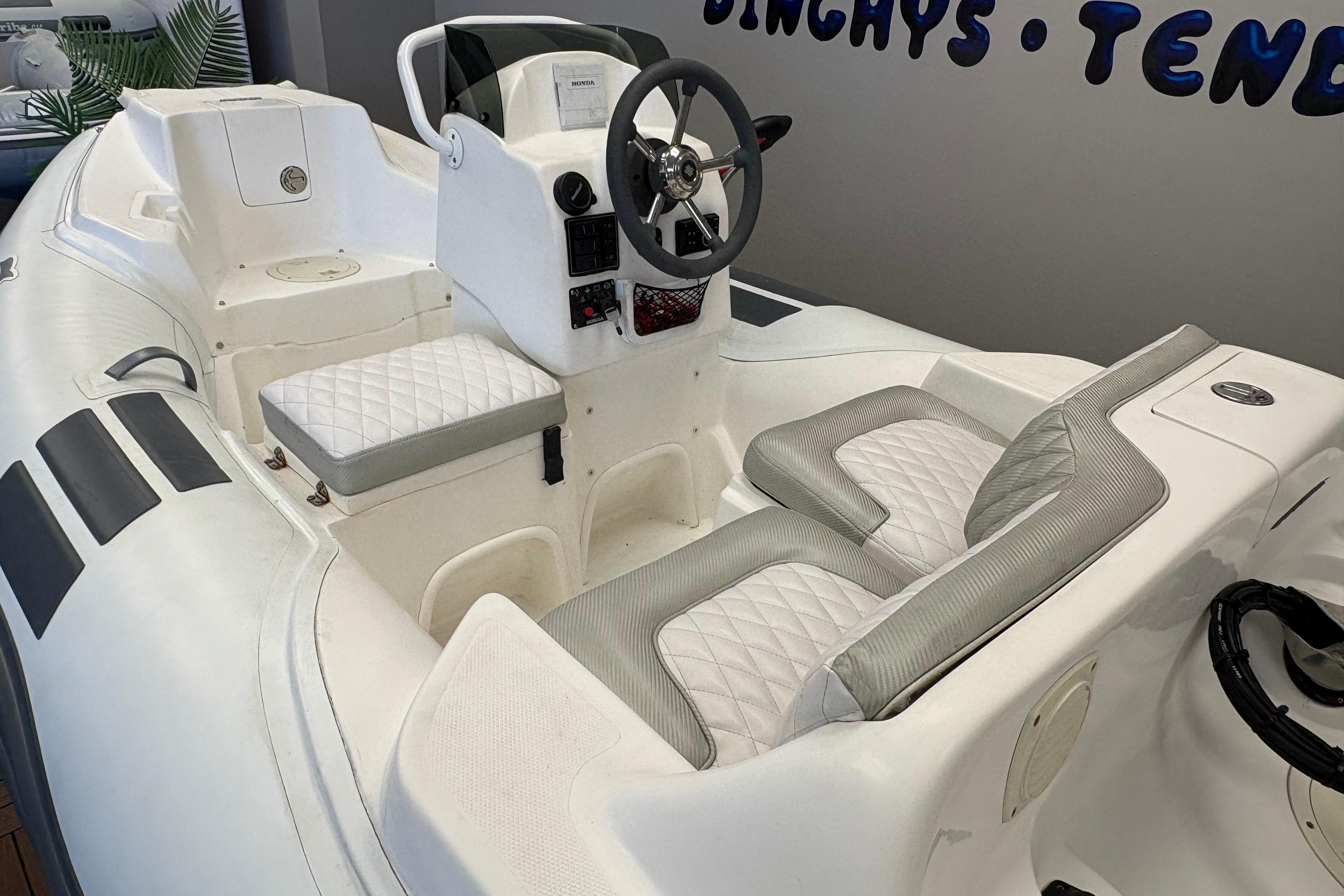 2019 Caribe DL12 inflatable boat interior with white quilted seating and steering console.