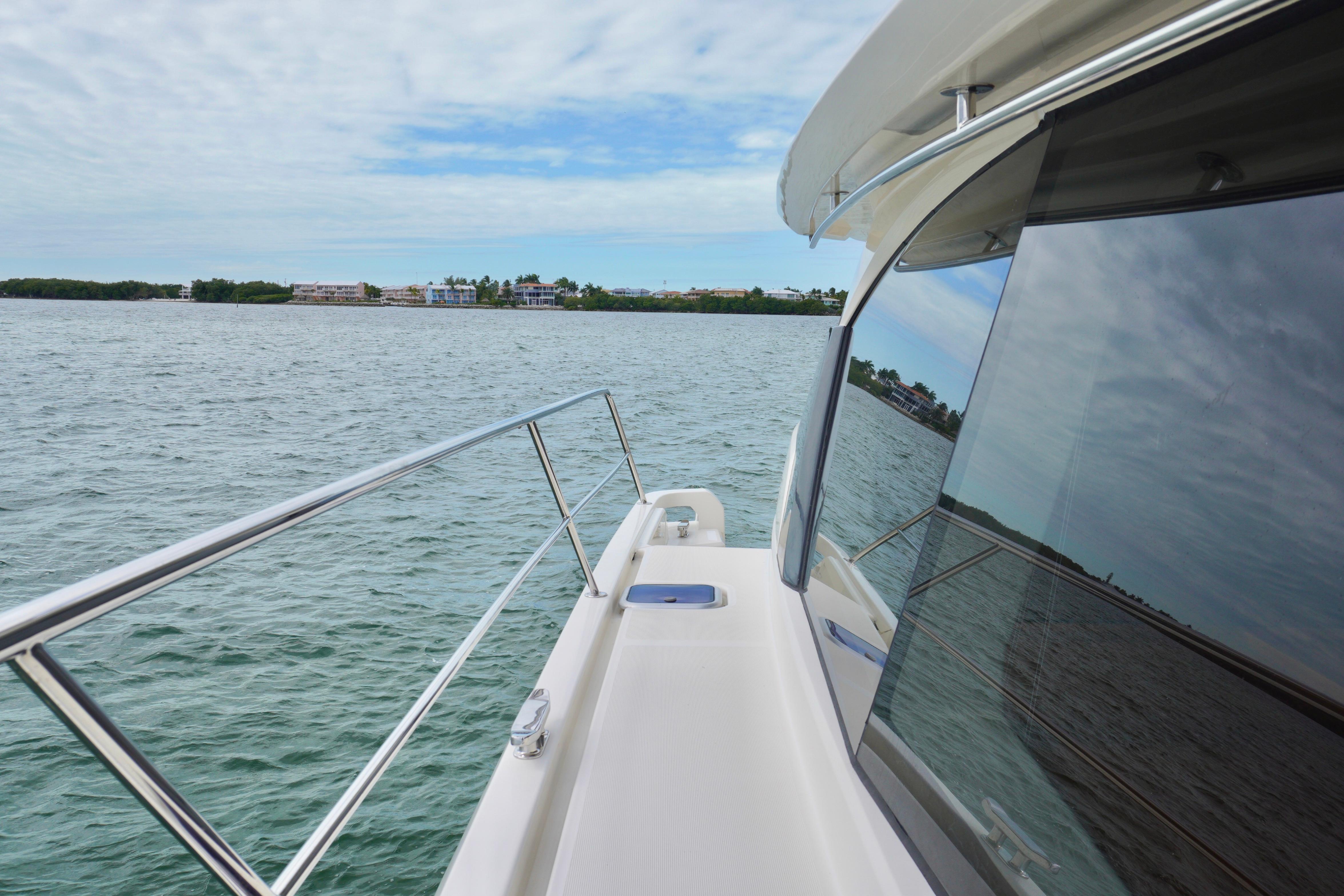 2017 Aquila 44 Yacht cruising on calm waters with scenic shoreline view.