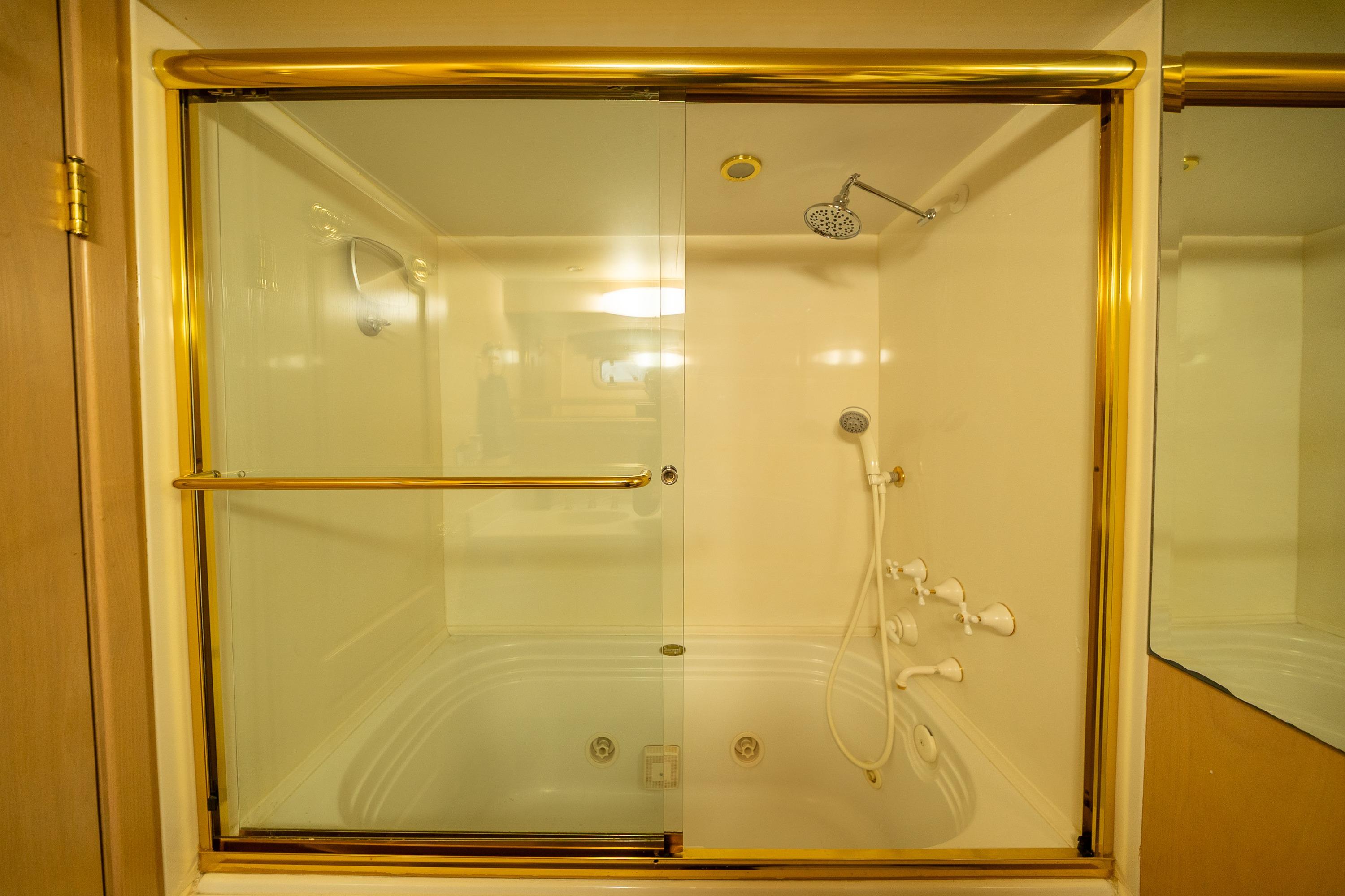Luxurious yacht bathroom with gold accents and glass shower doors, Palmer Marine 1989 model.