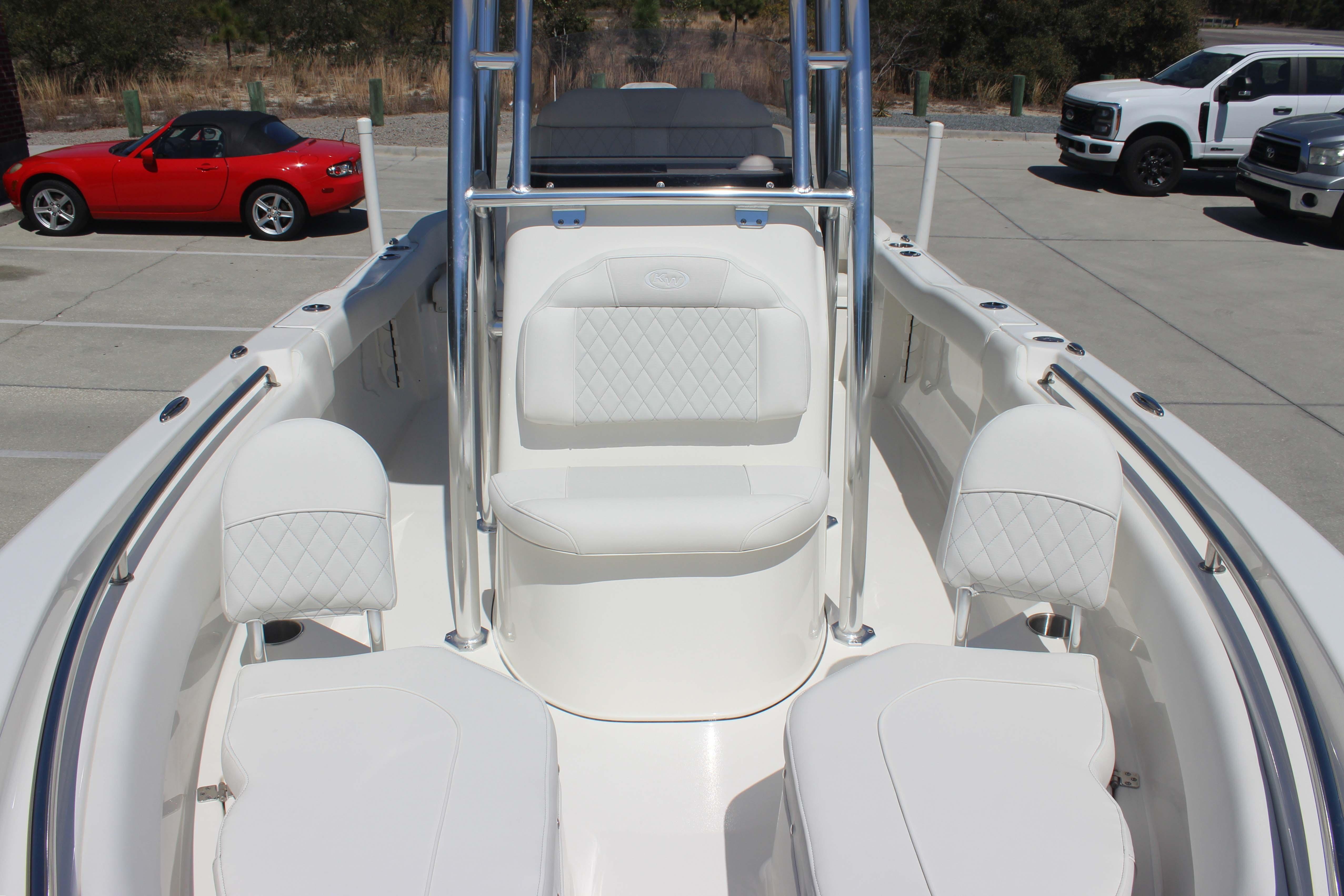 2026 Key West 203 FS boat interior with white seating, parked cars in the background.