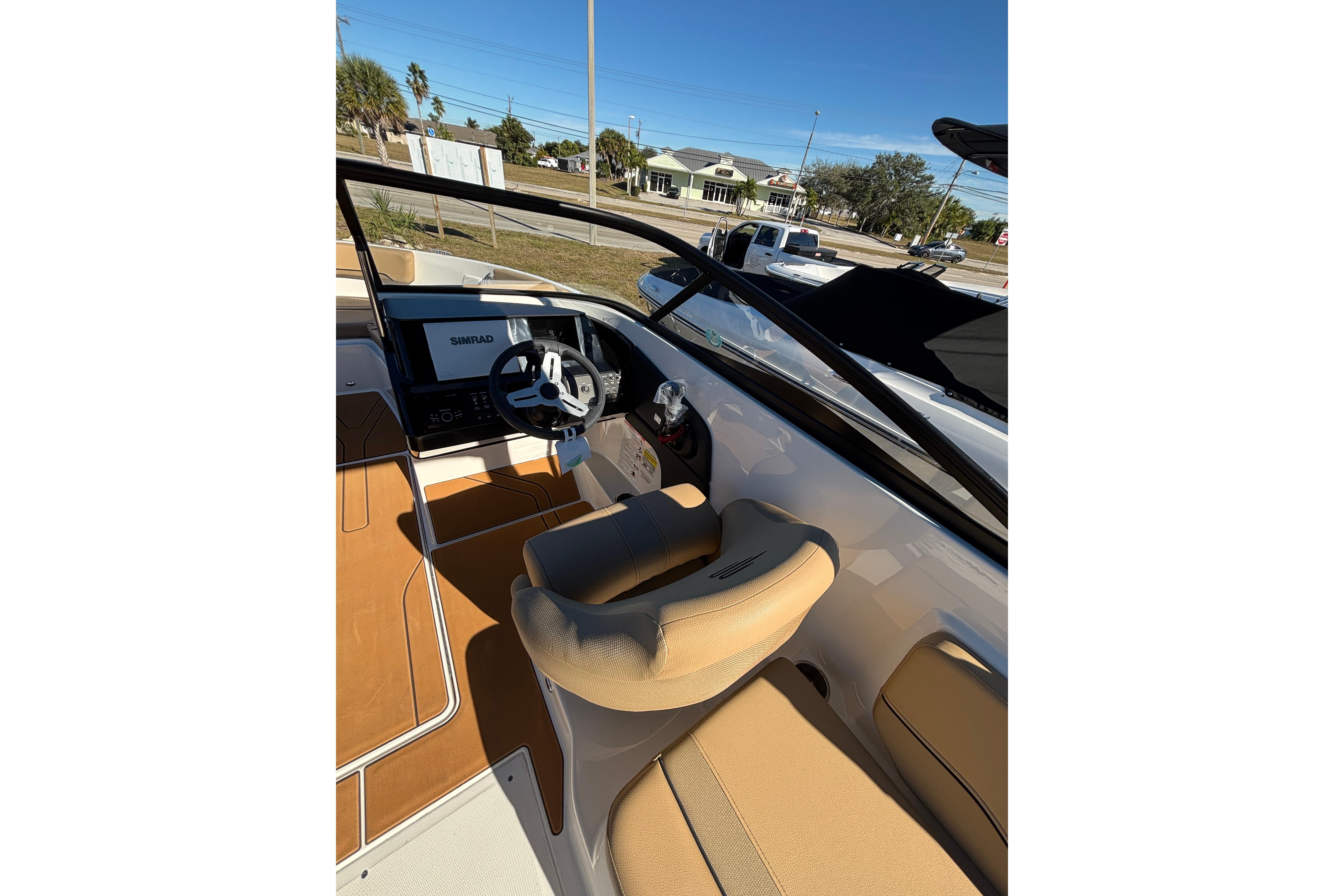 2025 Bayliner V20 boat interior with steering wheel and beige seating.