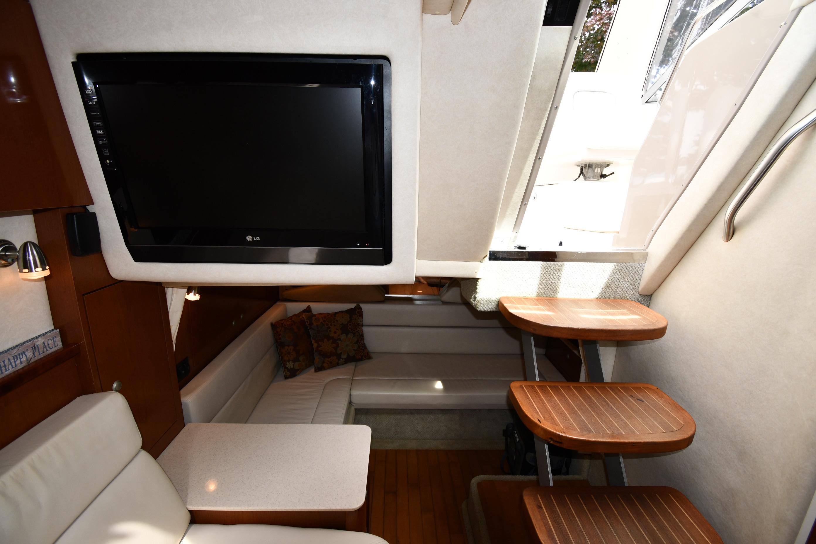 Interior of 2008 Sea Ray Sundancer 350 yacht with TV, seating, and wooden steps.