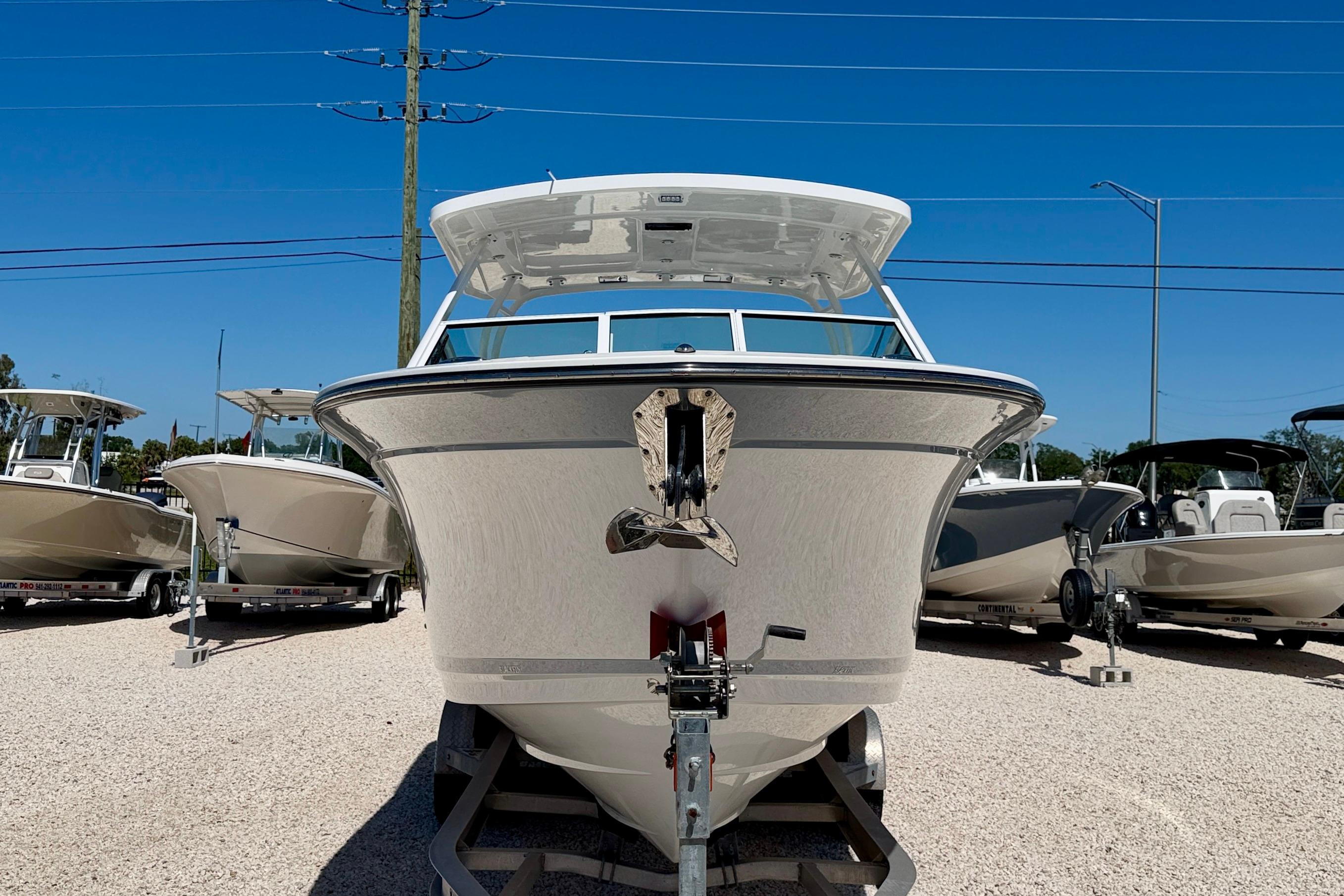 2023 Blackfin 272 DC boat on display in a sunny outdoor showroom.