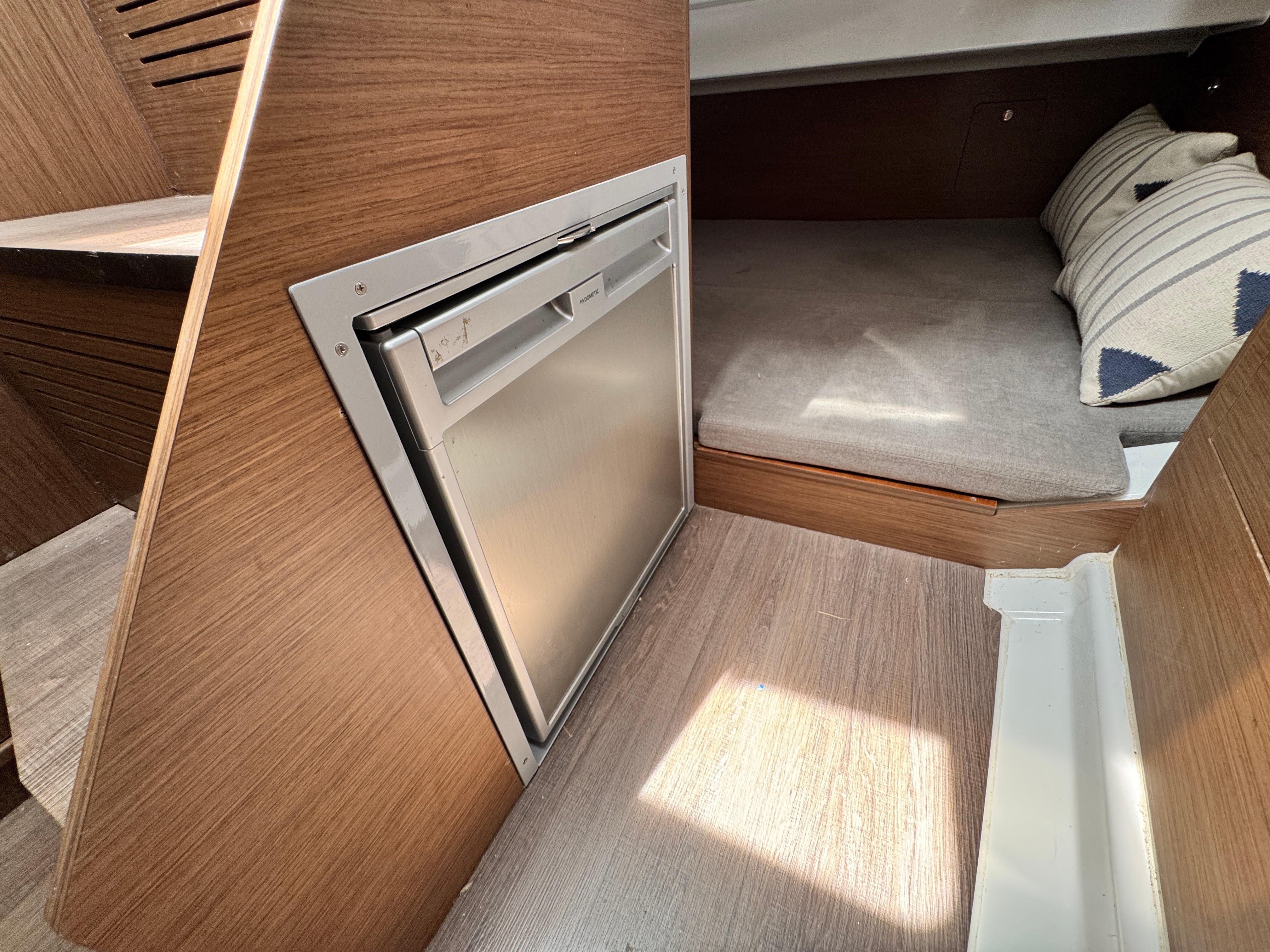 Interior of 2022 Beneteau Flyer 9 SUNdeck with compact fridge and cozy sleeping area.