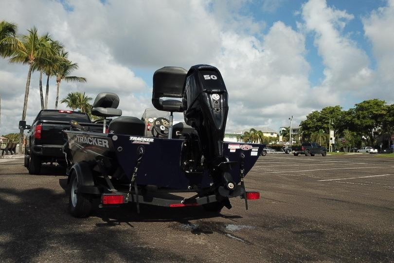 2020 Tracker Pro 170 boat on trailer, parked near palm trees under a cloudy sky.