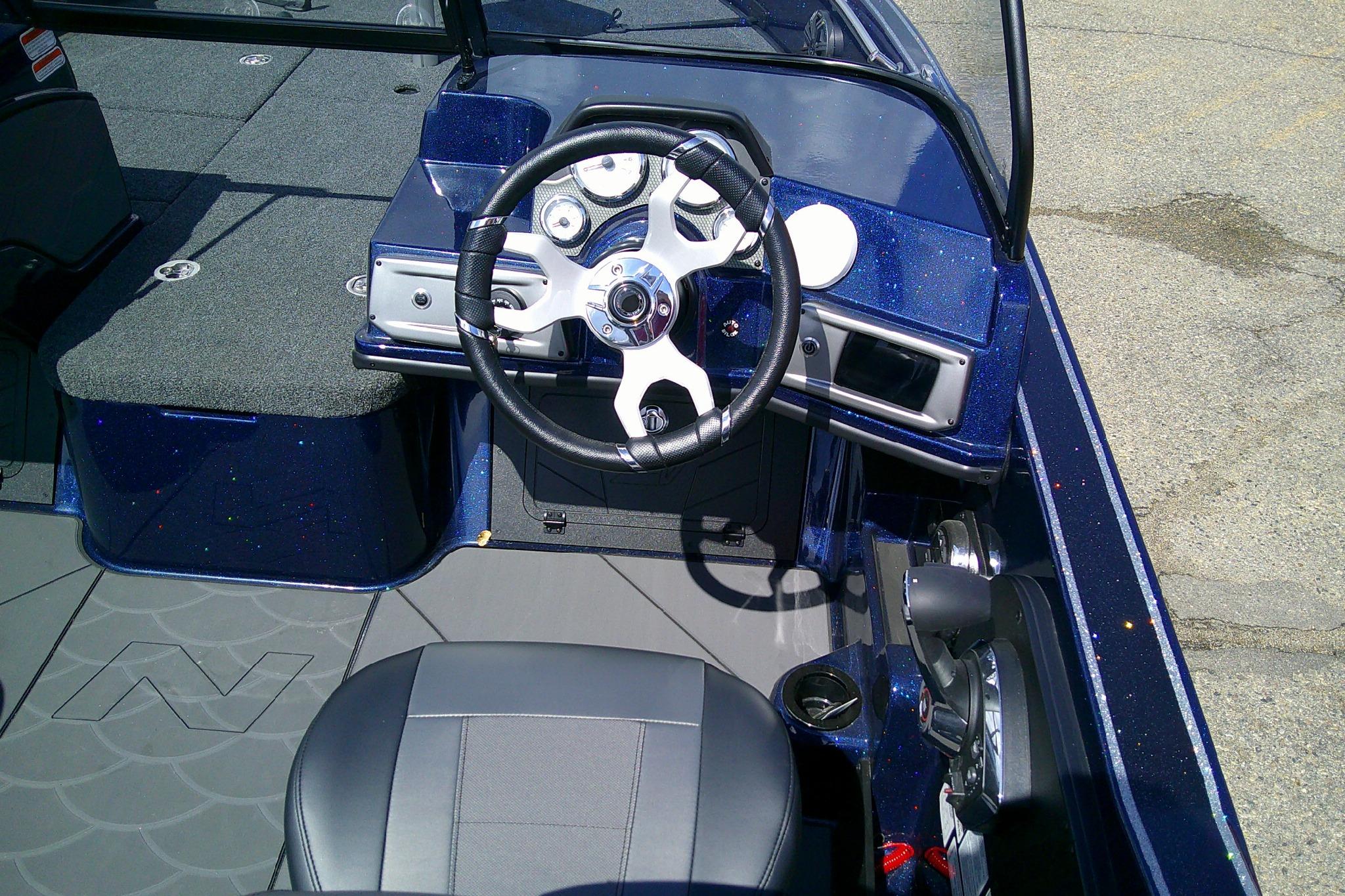 Interior view of a 2025 Nitro ZV20 Sport boat, featuring a sleek steering wheel and dashboard.