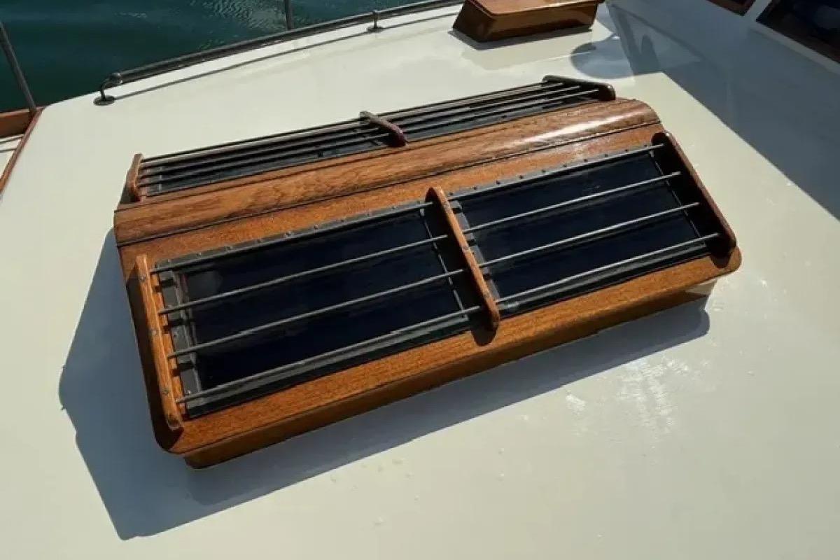 Wooden hatch on 2003 Snug Harbor Shearwater boat deck, featuring metal bars.