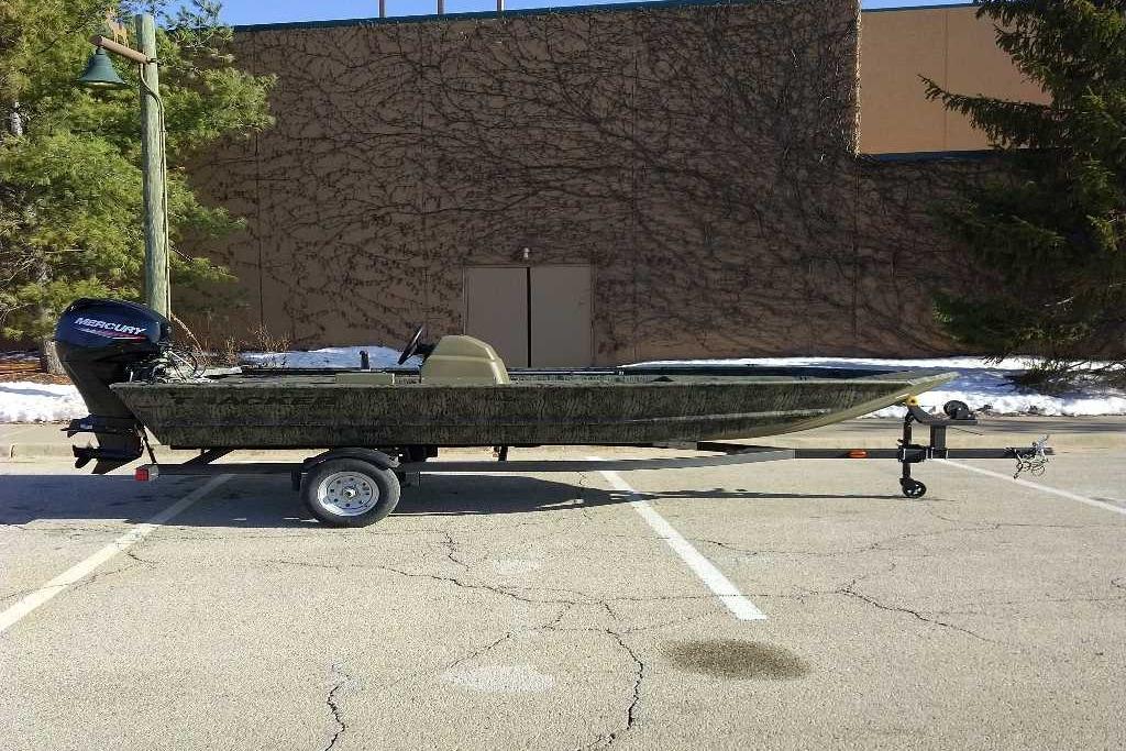 2026 Tracker Grizzly 1648 SC boat on trailer in parking lot.